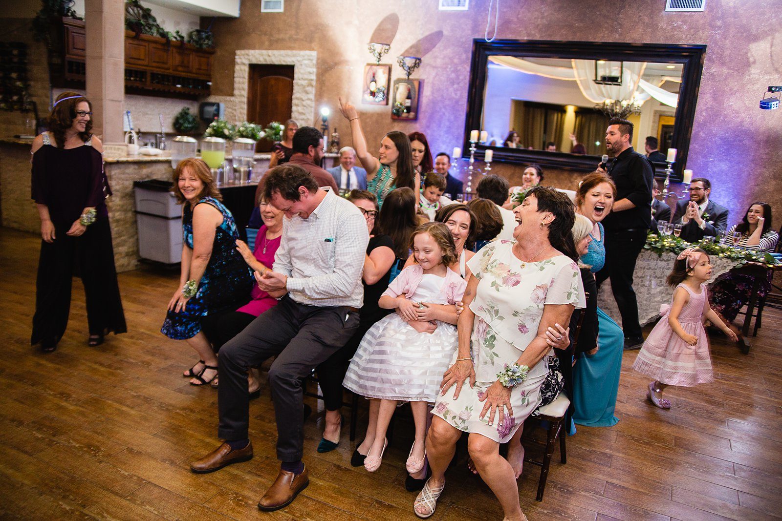 Guests playing a scavenger hunt game during the wedding reception by PMA Photography.