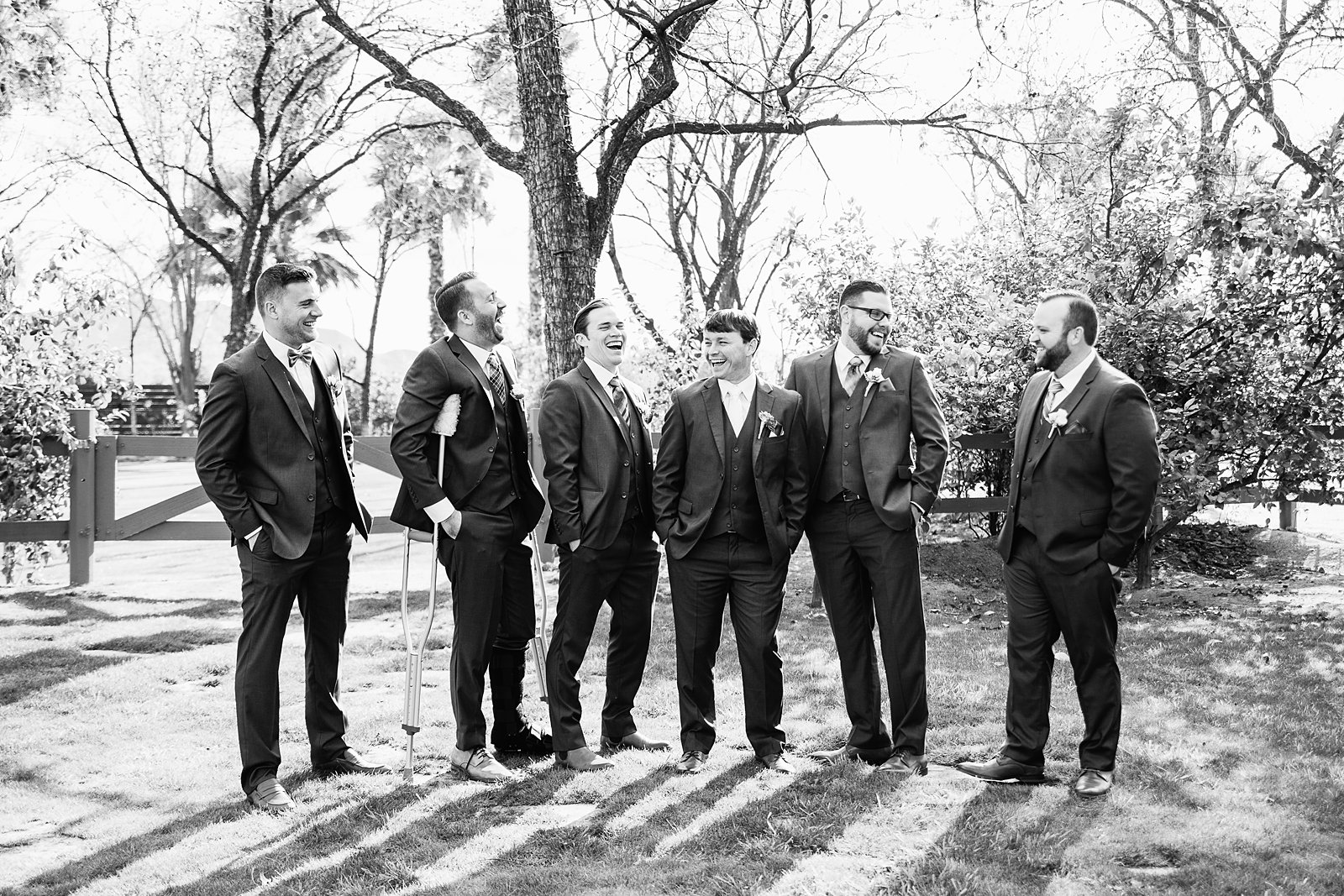 Groom and groomsmen laughing together at Venue At The Grove wedding by Phoenix wedding photographer PMA Photography.