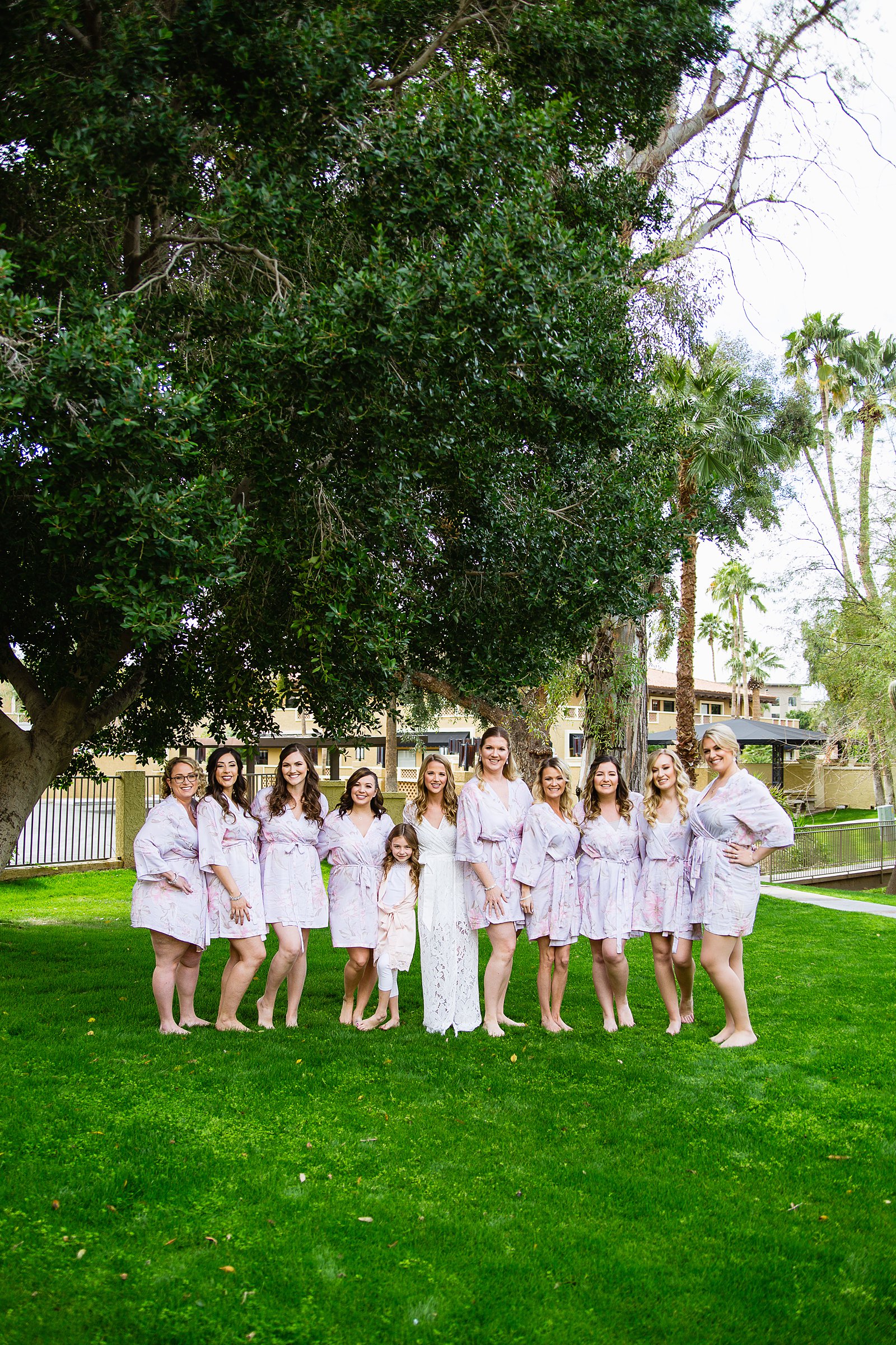 Bride and bridesmaids together in matching robes while getting ready for the wedding day by PMA Photography.