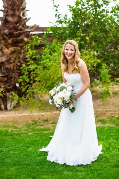 A happy bride laughing on her wedding day in a simple boho inspired wedding dress by Arizona wedding photographer PMA Photography.