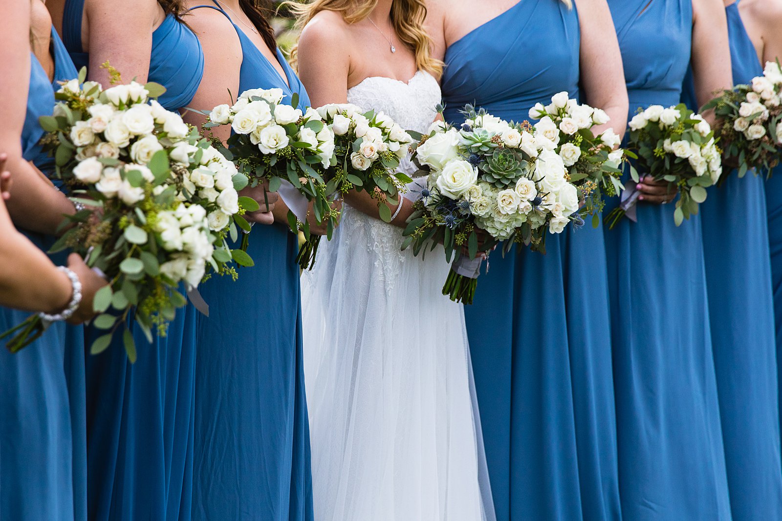 Simple rose and eucalyptus bridesmaids bouquet on blue wedding dresses by PMA Photography.