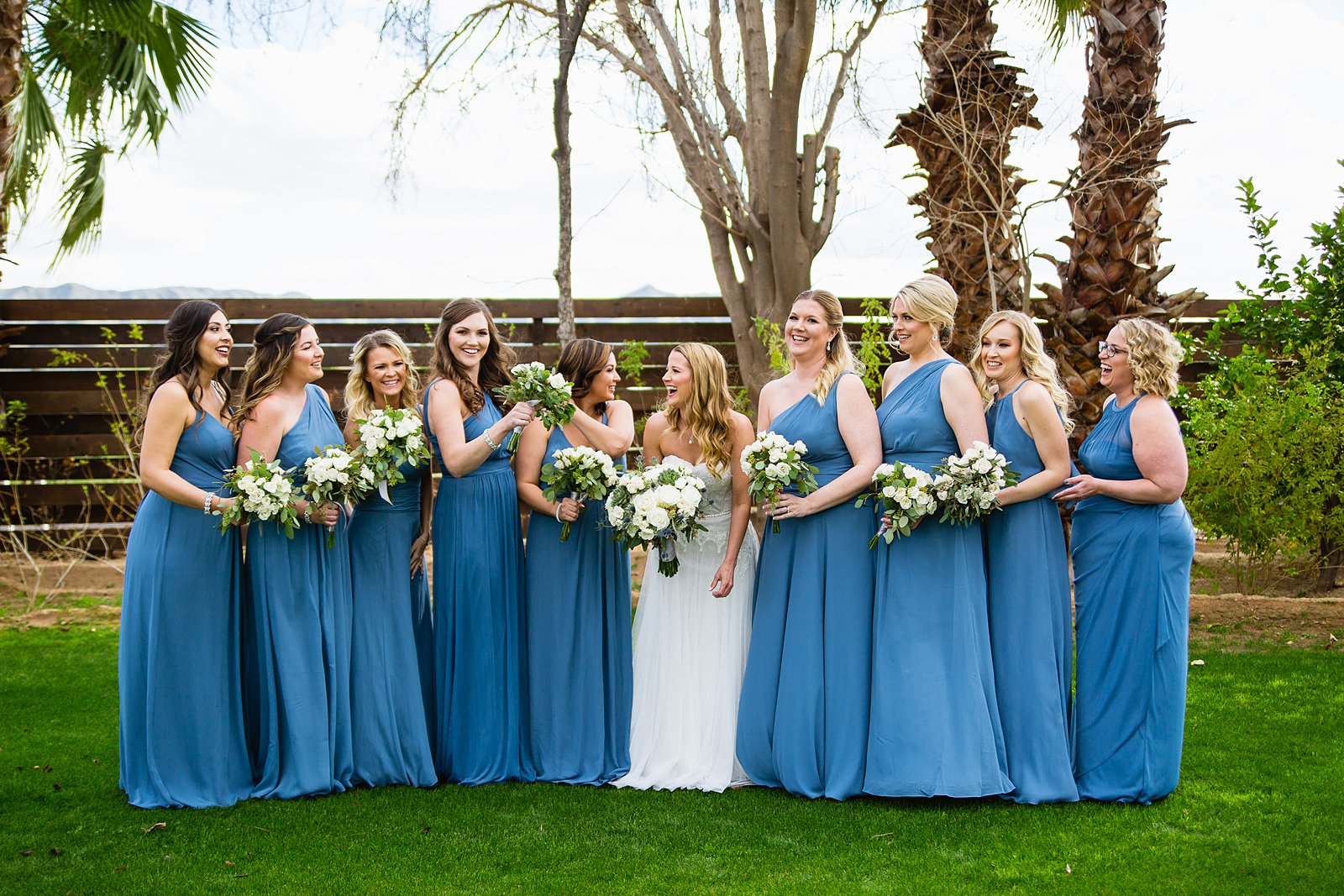Bride and bridesmaids laughing together at Venue At The Grove wedding by Phoenix wedding photographer PMA Photography.