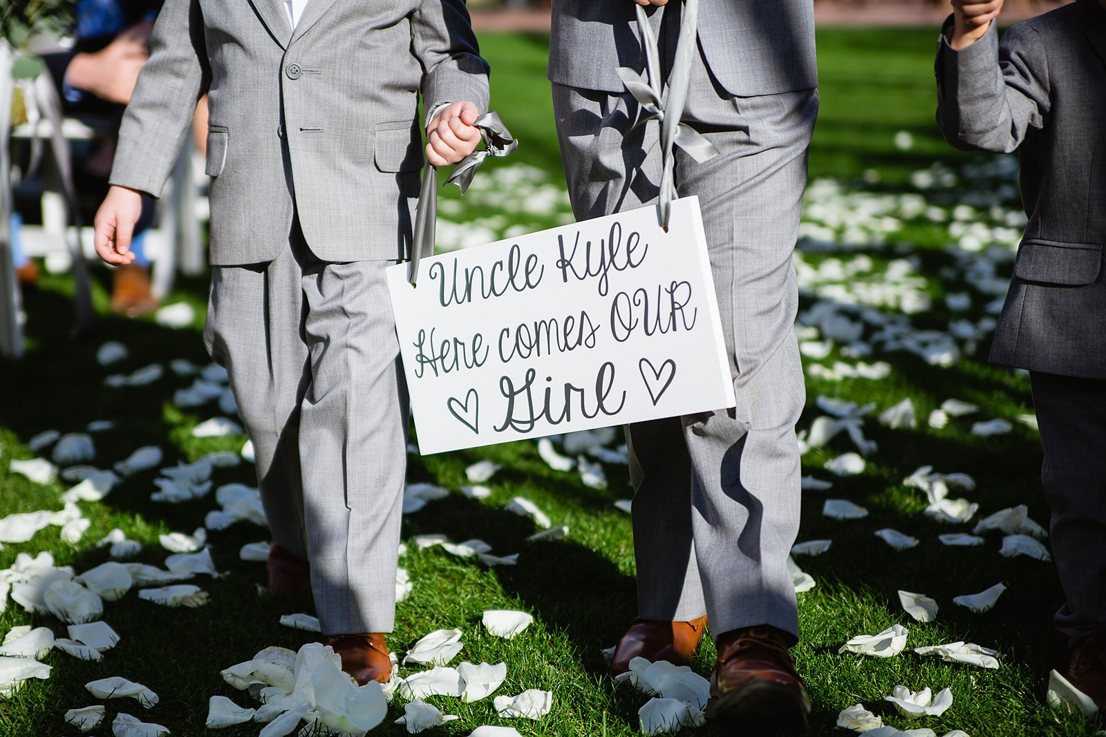 Ringbearers caring a sign saying "uncle here comes our girl" by Phoenix wedding photographer PMA Photography.