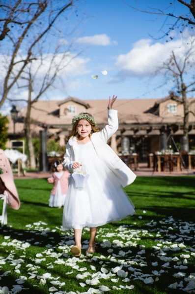 Flower girl tossing flowers down the aisle at a Venue at the Grove wedding by Arizona wedding photographer PMA Photography.