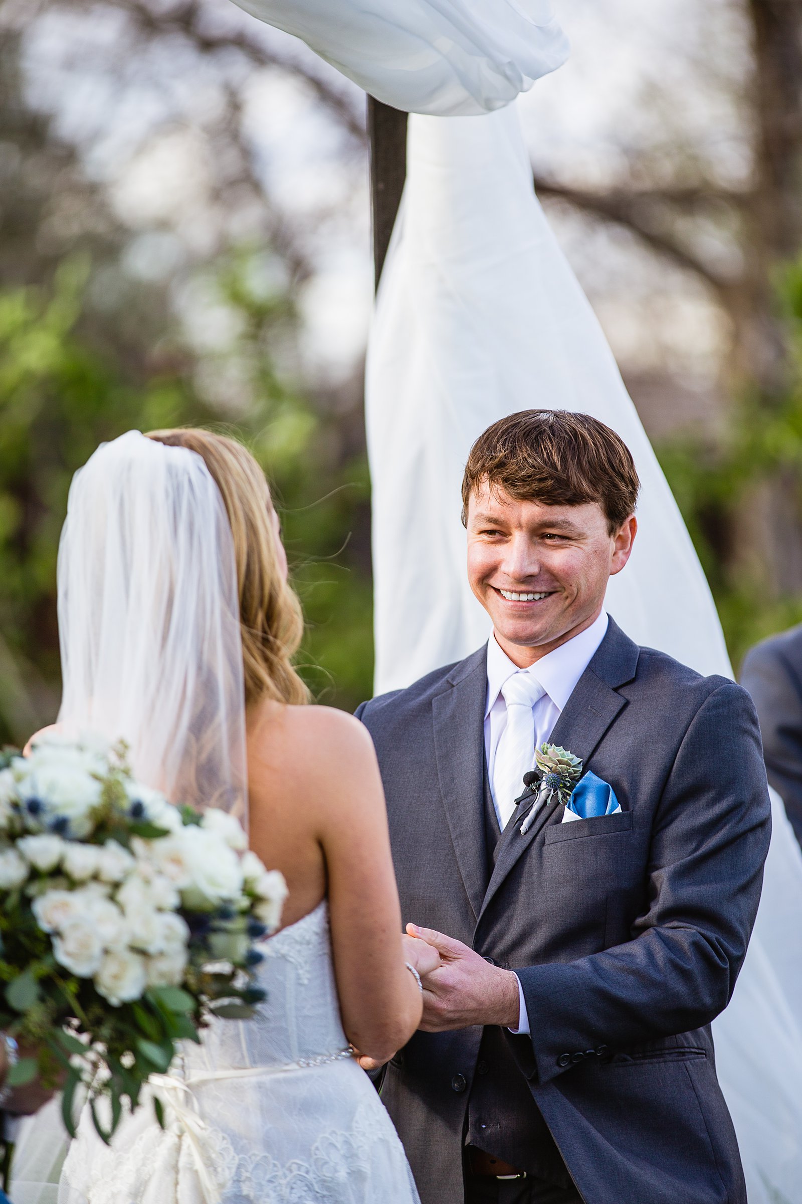 Groom looking at his bride during their wedding ceremony at Venue At The Grove by Phoenix wedding photographer PMA Photography.