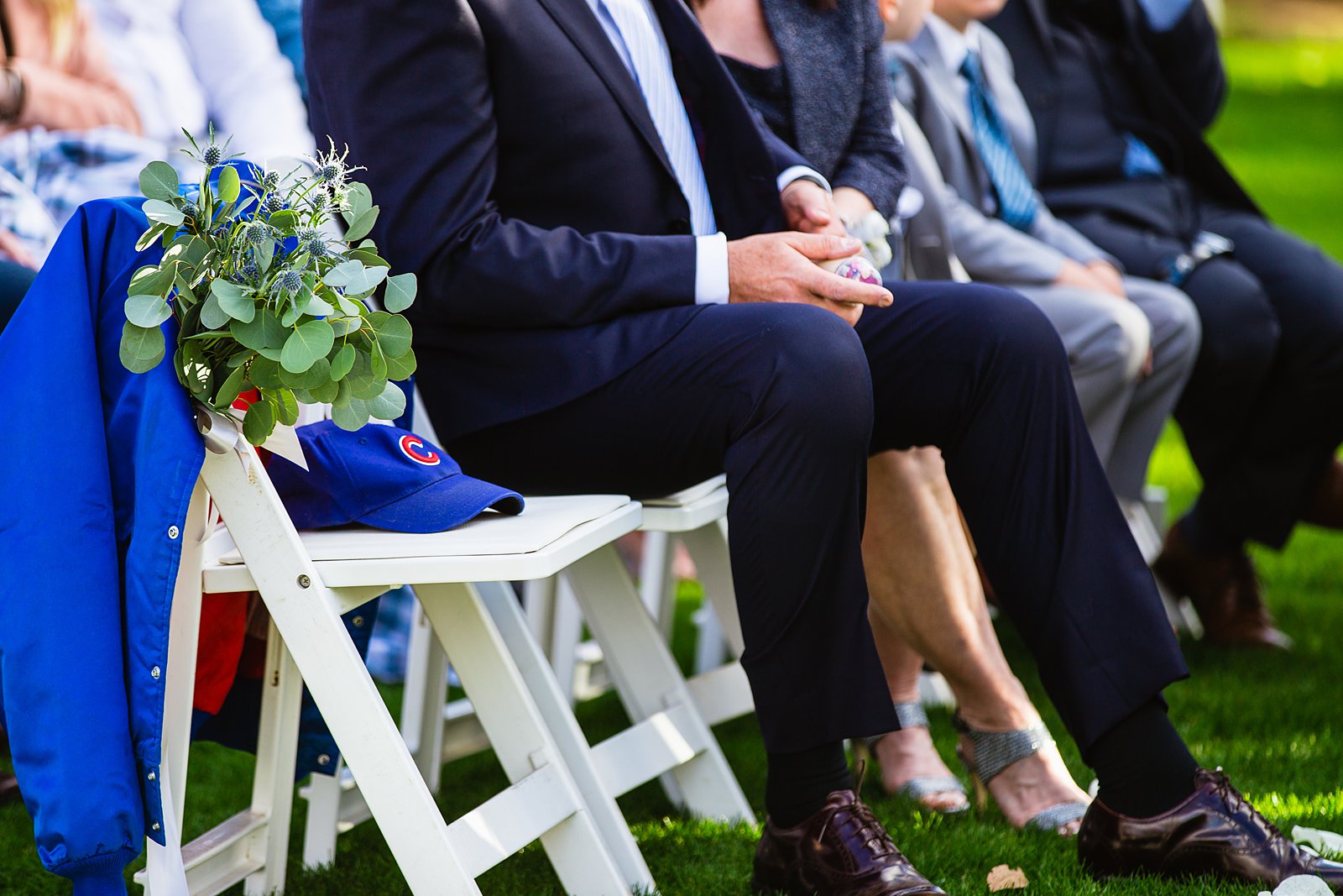 Remembrance chair with bride's father's cubs jacket and hat at the wedding ceremon by Arizona wedding photographer PMA Photography.
