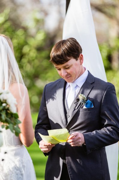 Groom reading his wedding vows during the wedding ceremony at Venue At The Grove by Phoenix wedding photographer PMA Photography.