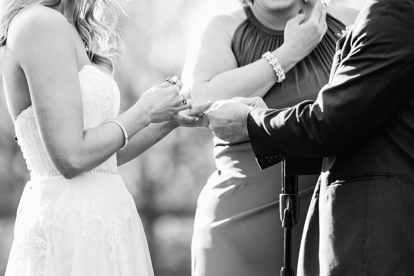 Bride and Groom exchange rings during their wedding ceremony at Venue At The Grove by Arizona wedding photographer PMA Photography.