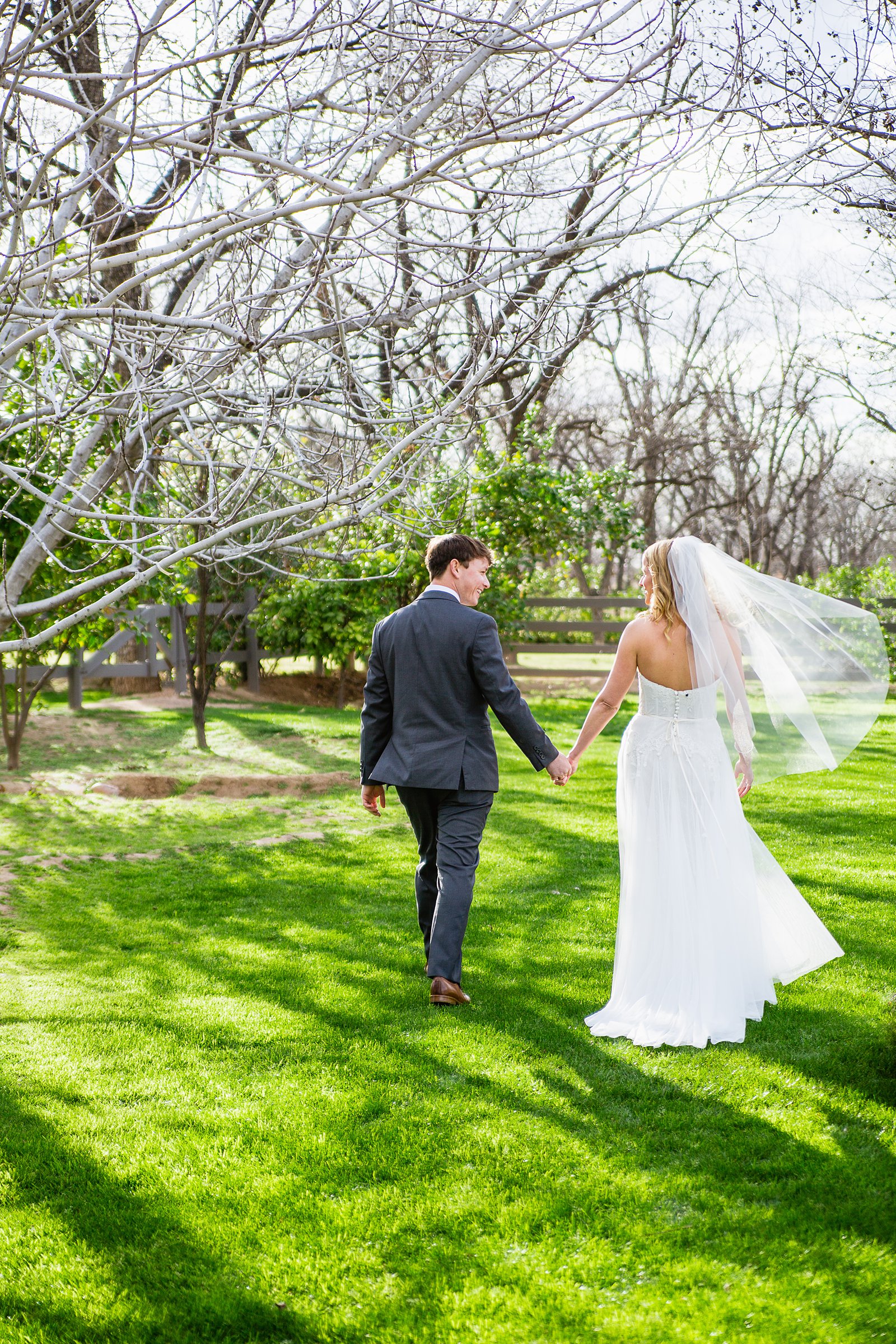 Bride and Groom walking together during their Venue At The Grove wedding by Phoenix wedding photographer PMA Photography.