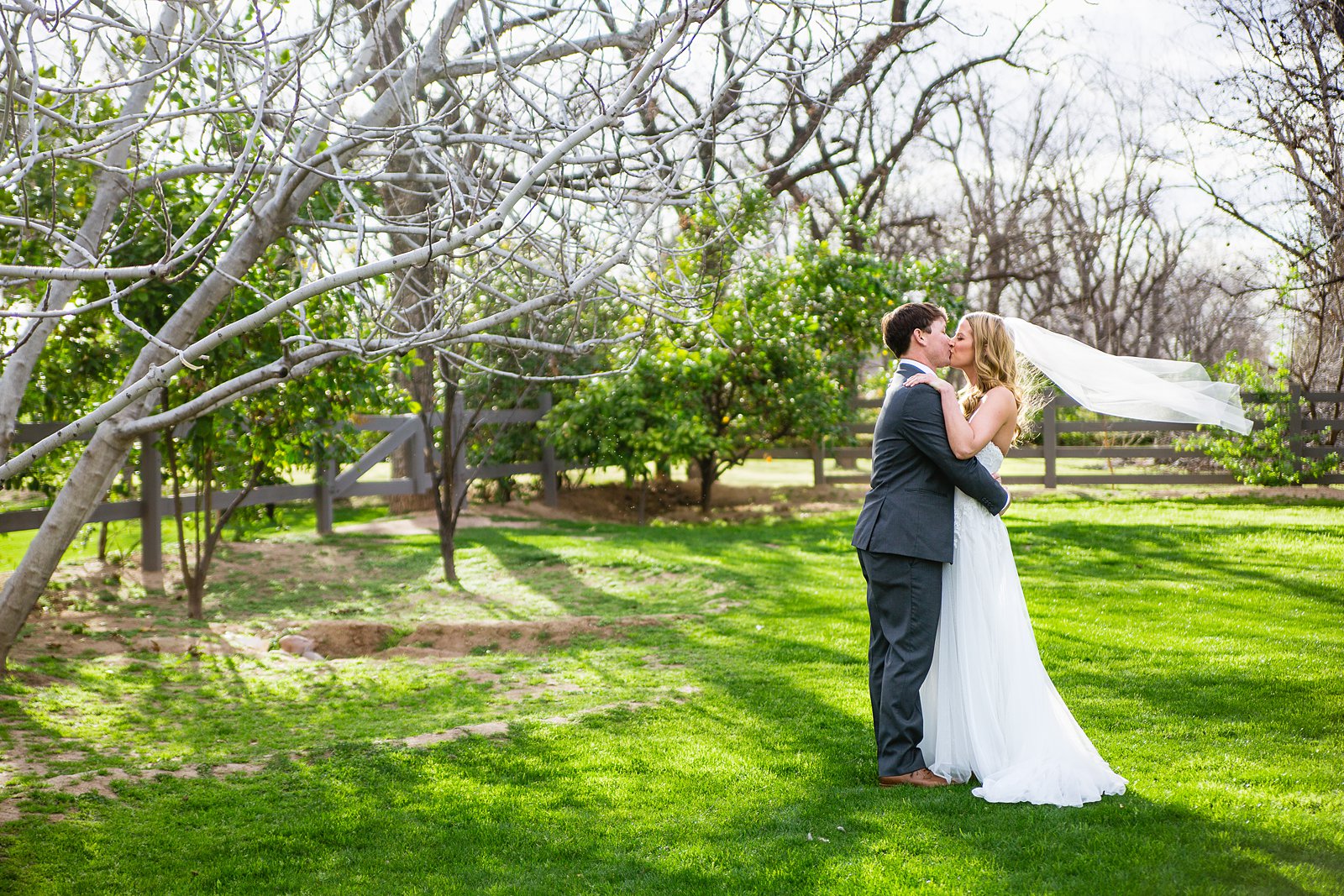 Bride and Groom share a kiss during their Venue At The Grove wedding by Arizona wedding photographer PMA Photography.