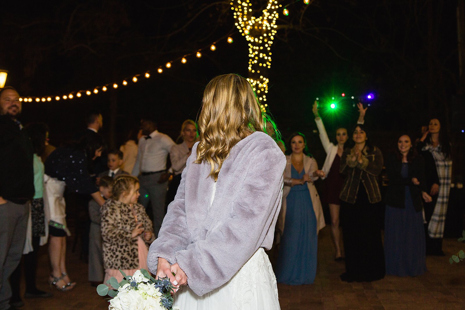 Bouquet toss at Venue At The Grove wedding reception by Phoenix wedding photographer PMA Photography.