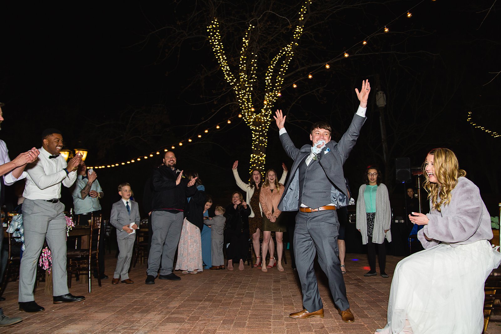 Garter toss at Venue At The Grove wedding reception by Phoenix wedding photographer PMA Photography.