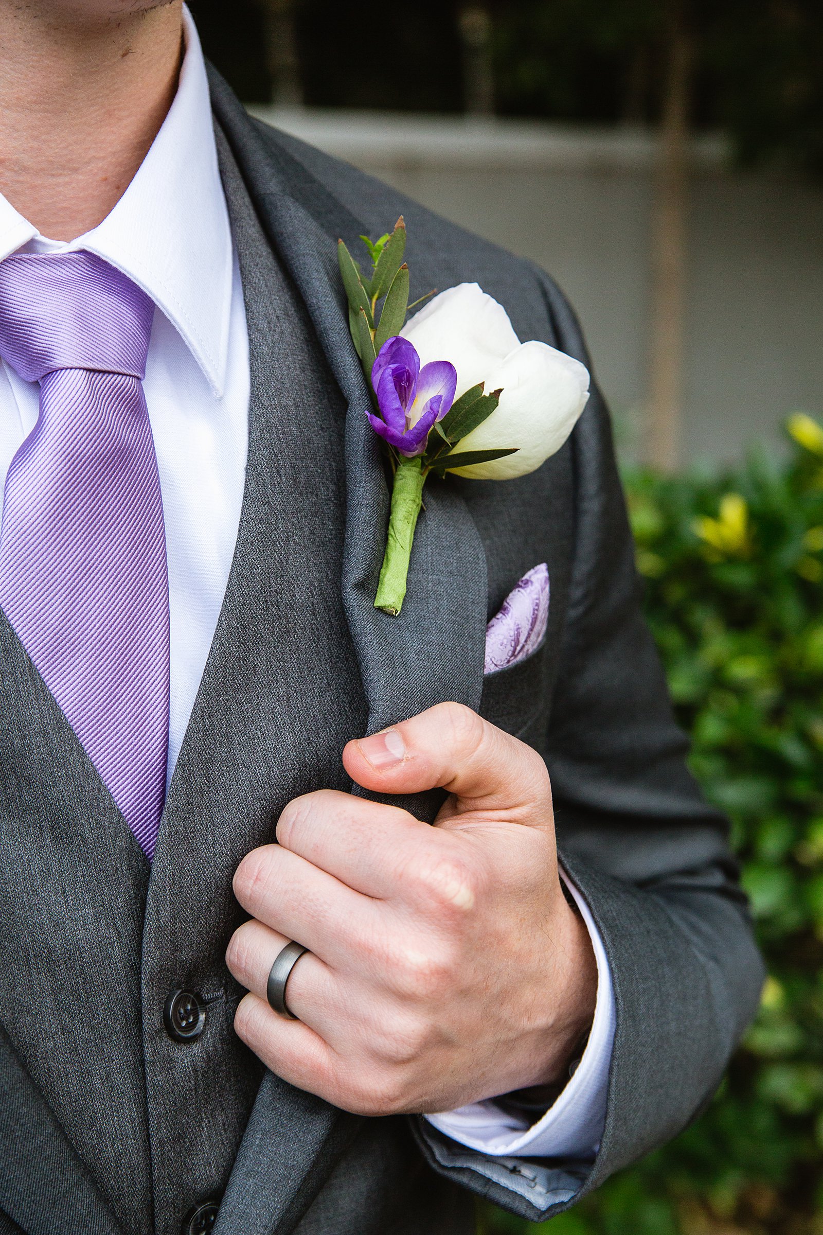 Groom's white and purple garden boutonniere with lilac accents by PMA Photography.