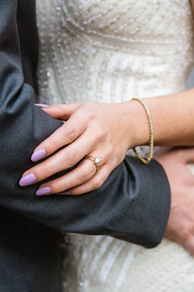Bride's wedding ring as she hold's her groom on their wedding day by PMA Photography.