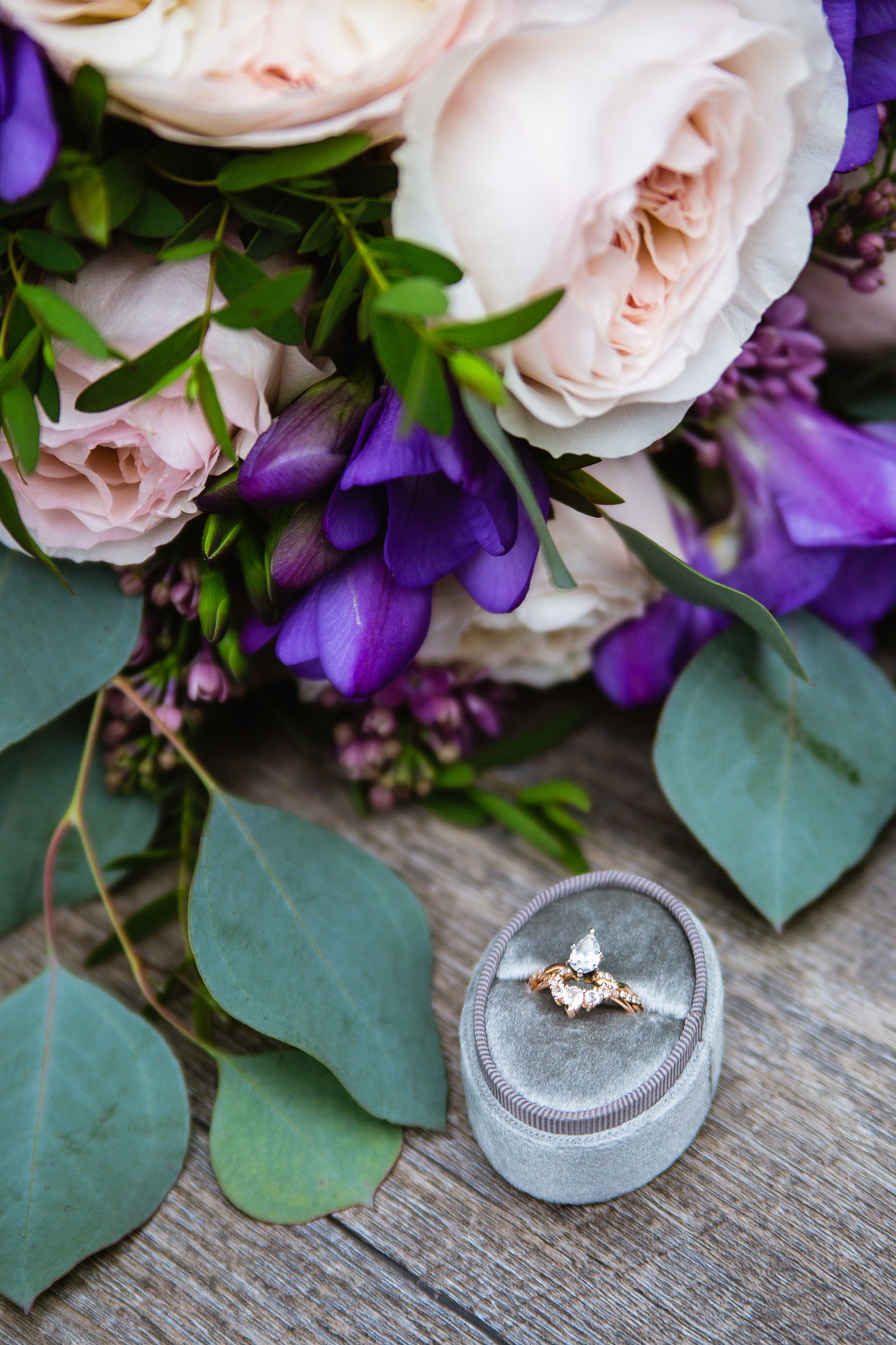 Bride's unique wedding ring and band in front of her garden inspired pink and purple bouquet by PMA Photography.