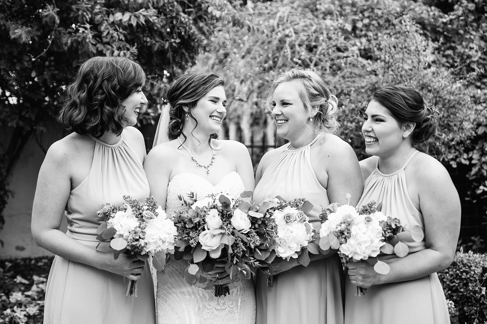 Bride and bridesmaids laughing together at The Wright House wedding by Mesa wedding photographer PMA Photography.