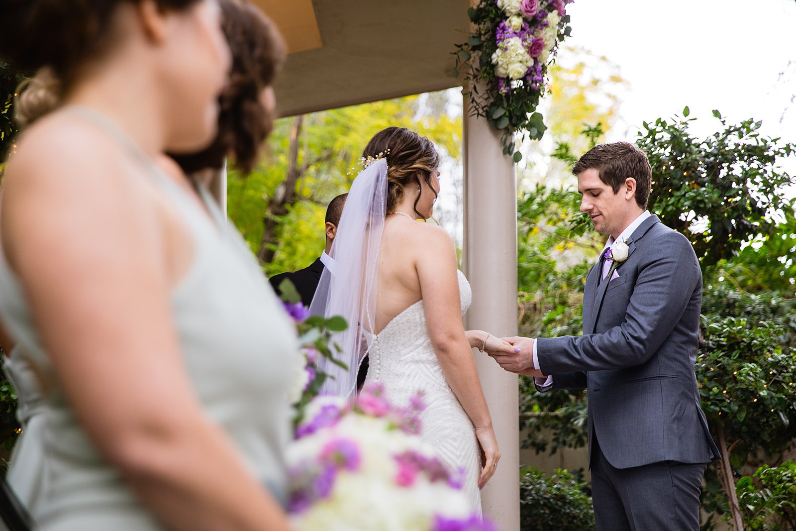 Bride and Groom exchange rings during their wedding ceremony at The Wright House by Arizona wedding photographer PMA Photography.