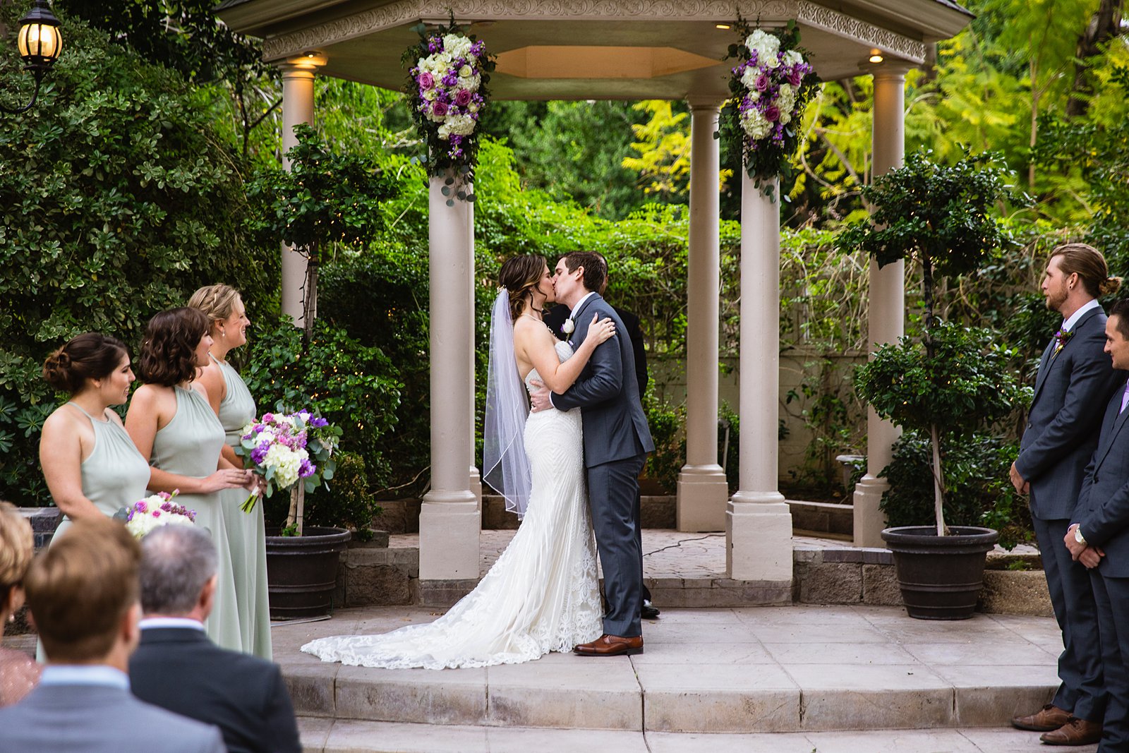 Bride and Groom share their first kiss during their wedding ceremony at The Wright House by Arizona wedding photographer PMA Photography.