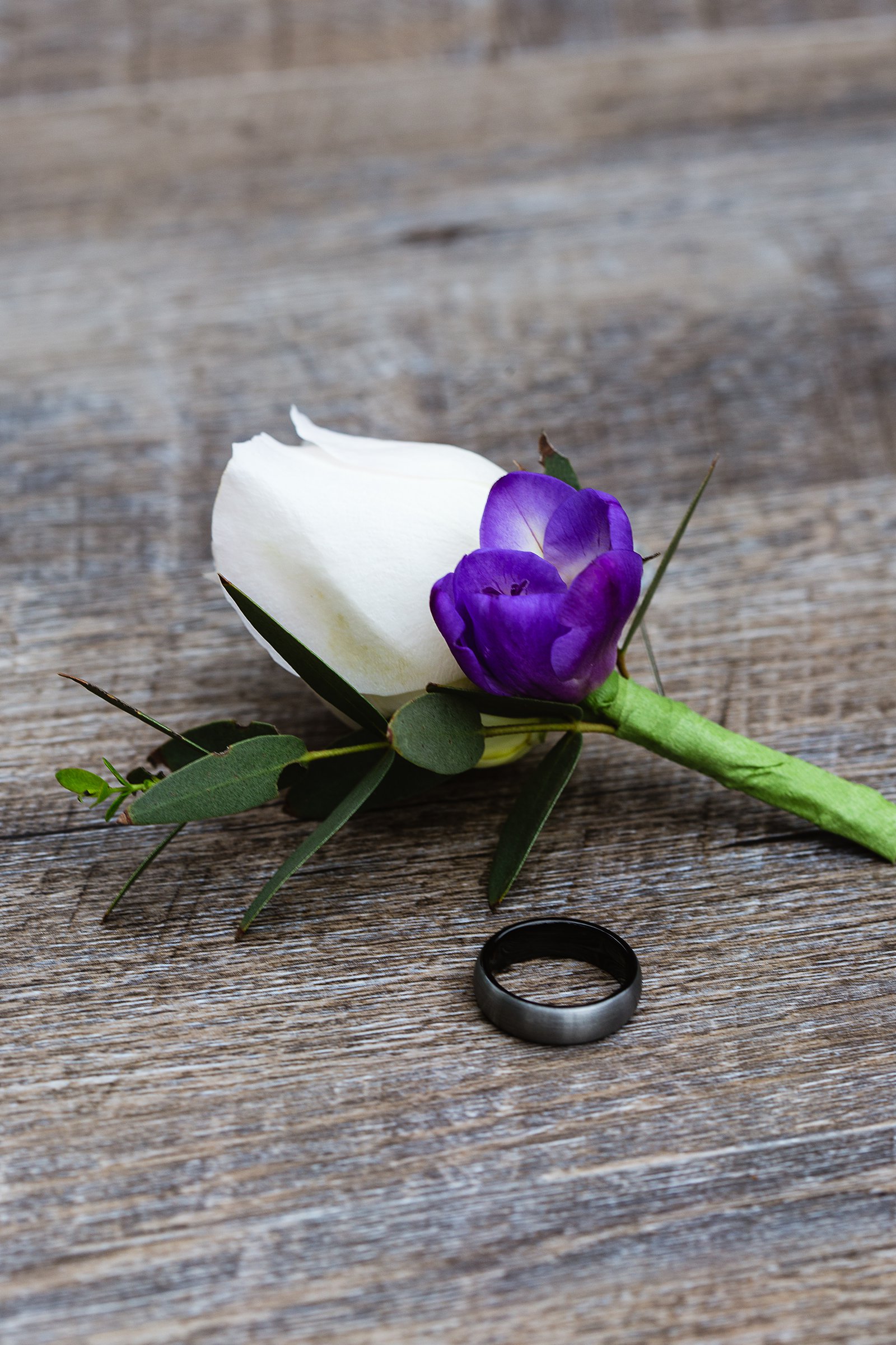 Groom's dark grey wedding band and garden inspired boutonniere by PMA Photography.