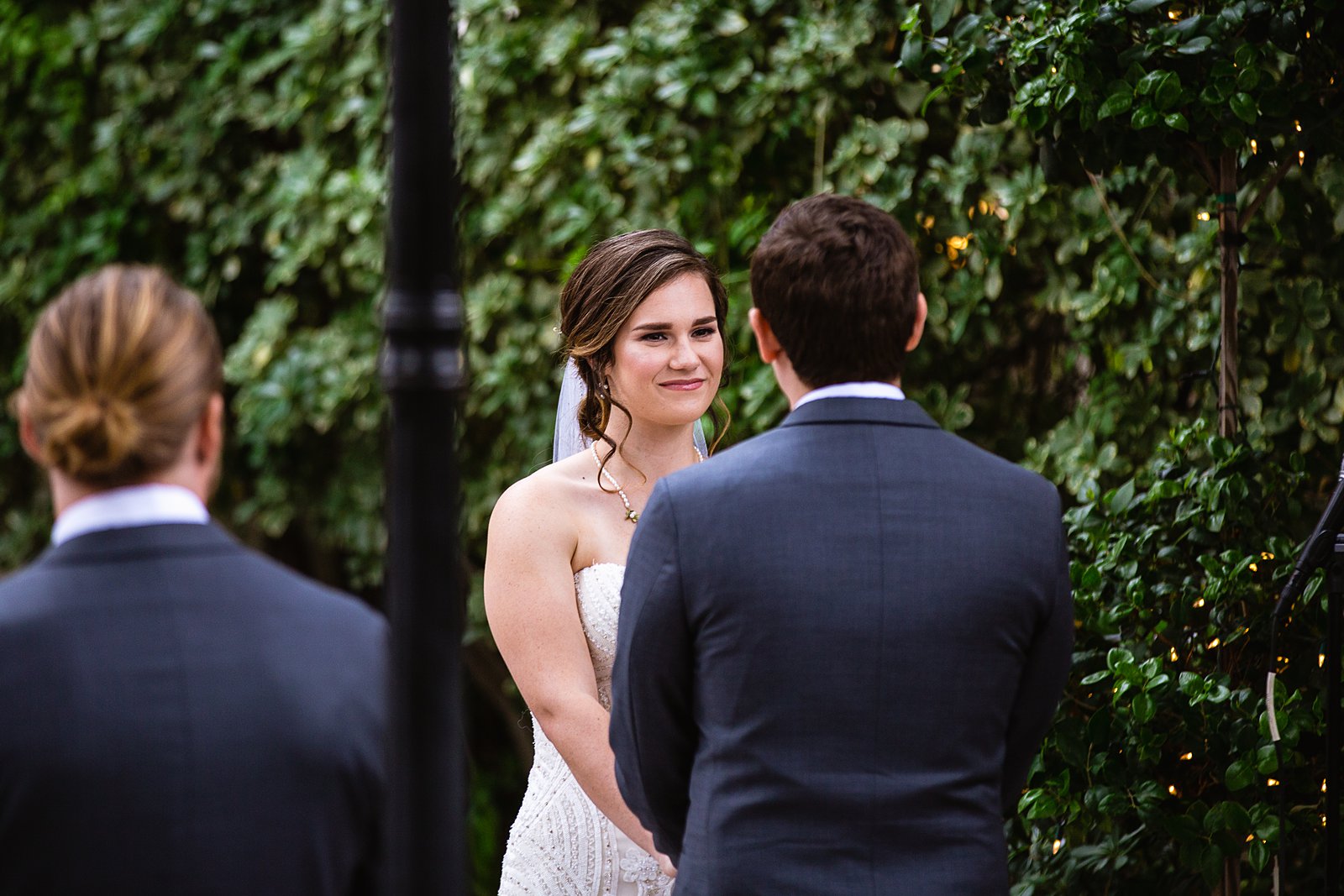 Bride looking at her groom during their wedding ceremony at The Wright House by Mesa wedding photographer PMA Photography.