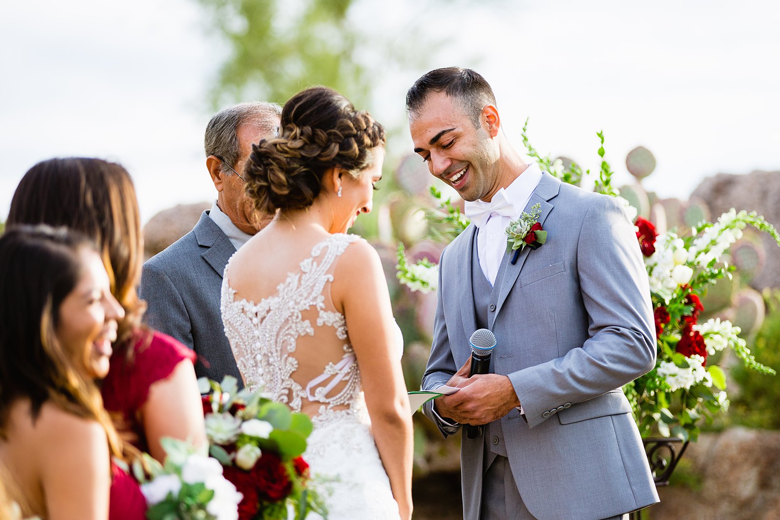 Groom smiling during his vows during a wedding ceremony by Phoenix wedding photographer PMA Photography.