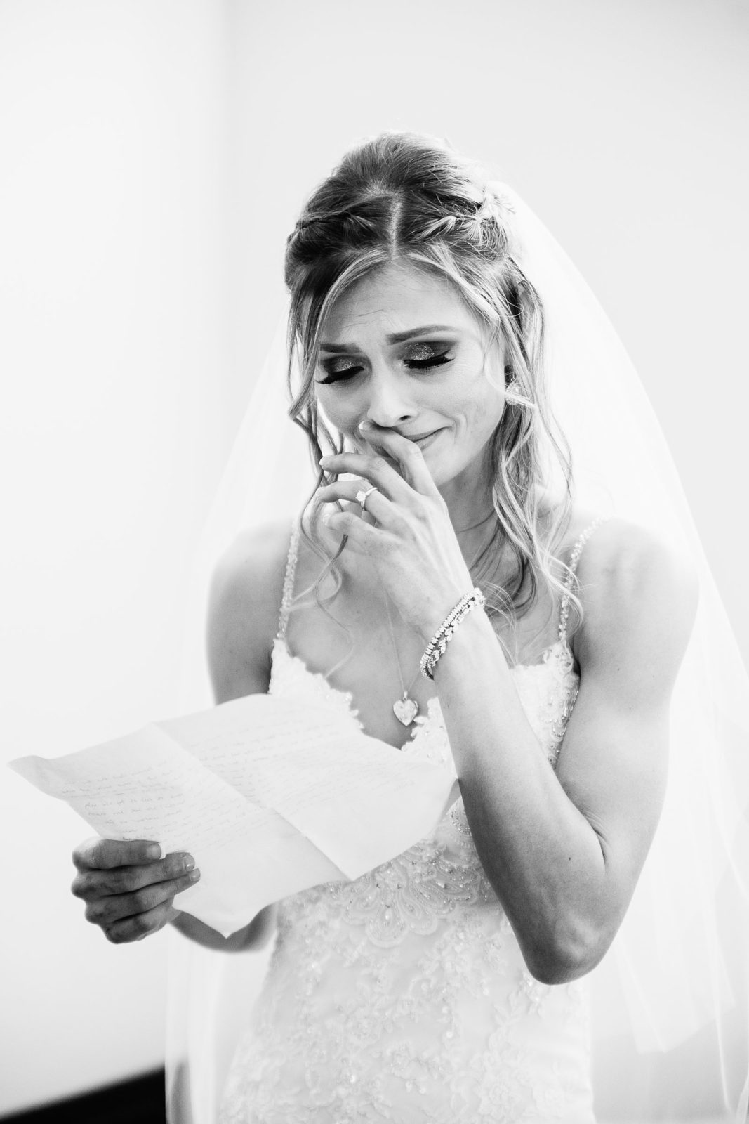 Bride reading a letter from her groom before the ceremony by Arizona wedding photographer PMA Photography.