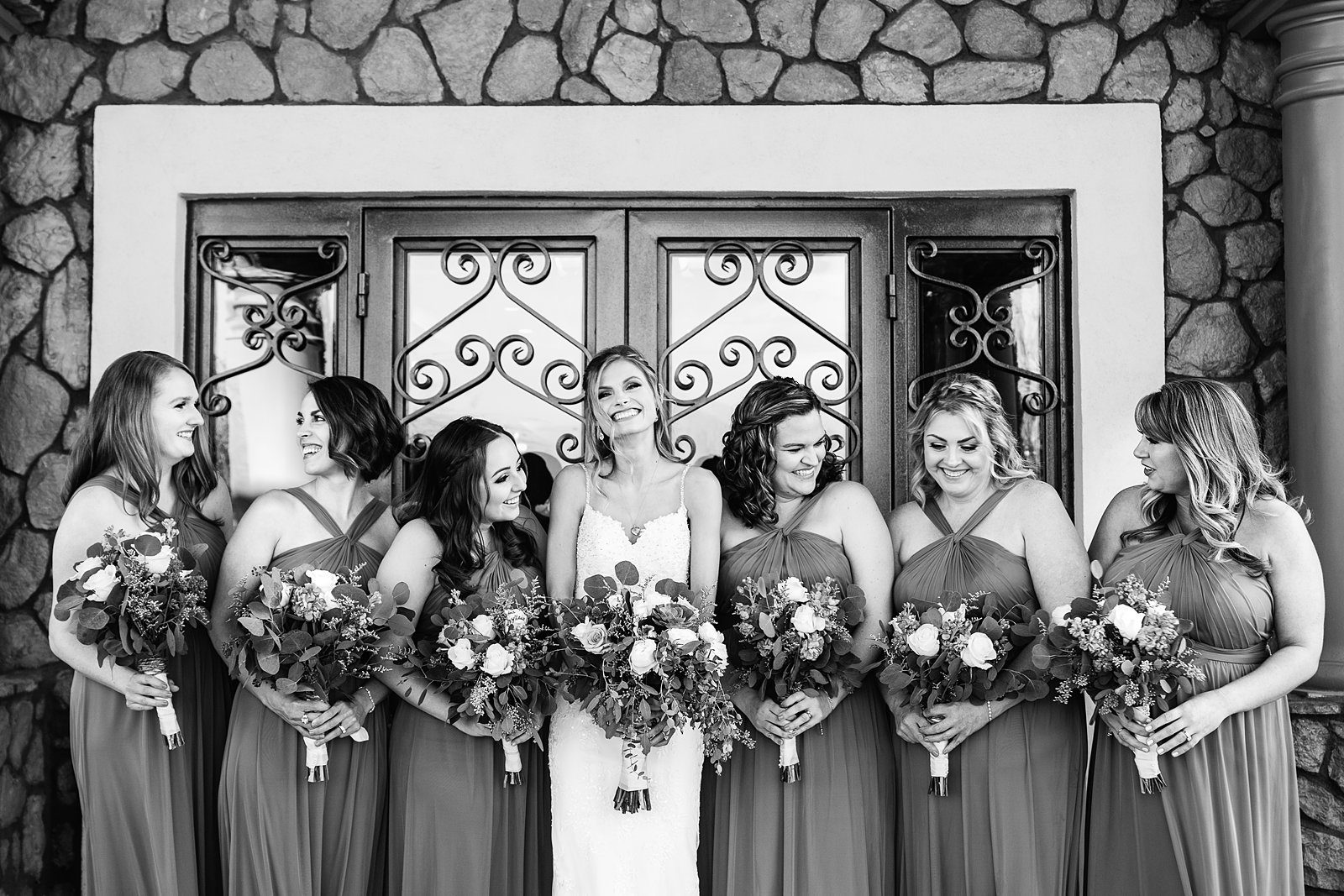 Bride and bridesmaids laughing together at Superstition Manor wedding by Mesa wedding photographer PMA Photography.