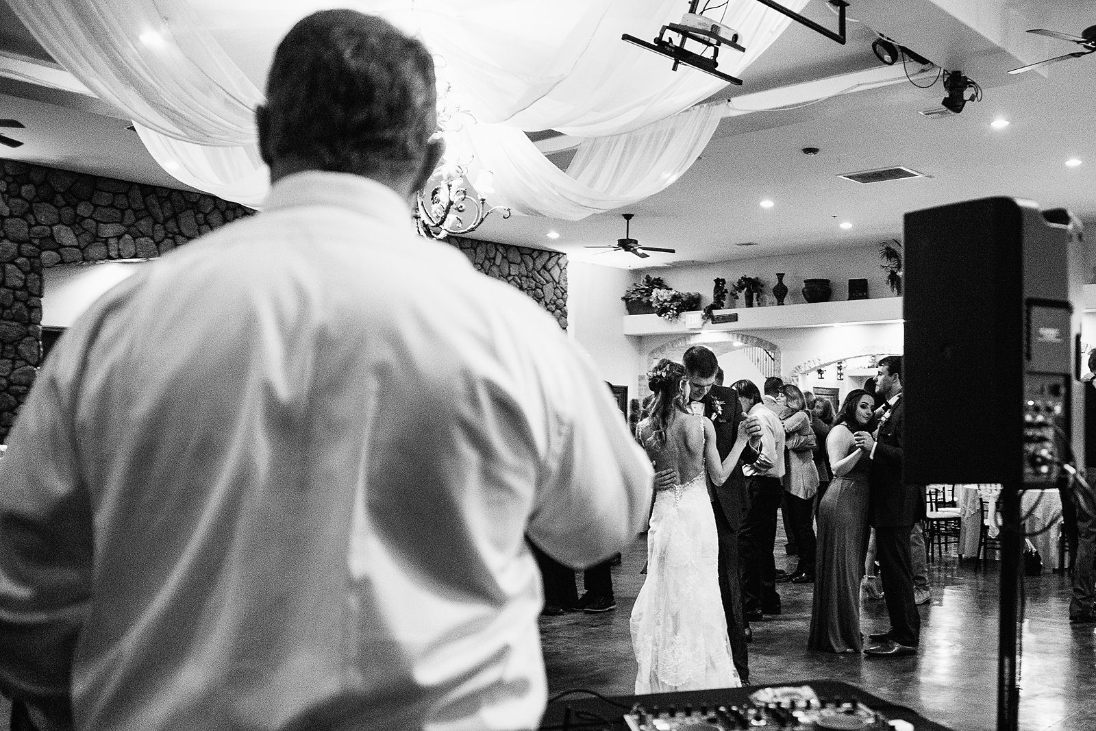 Bride and groom share a dance with guests while the bride's dad sings a song.