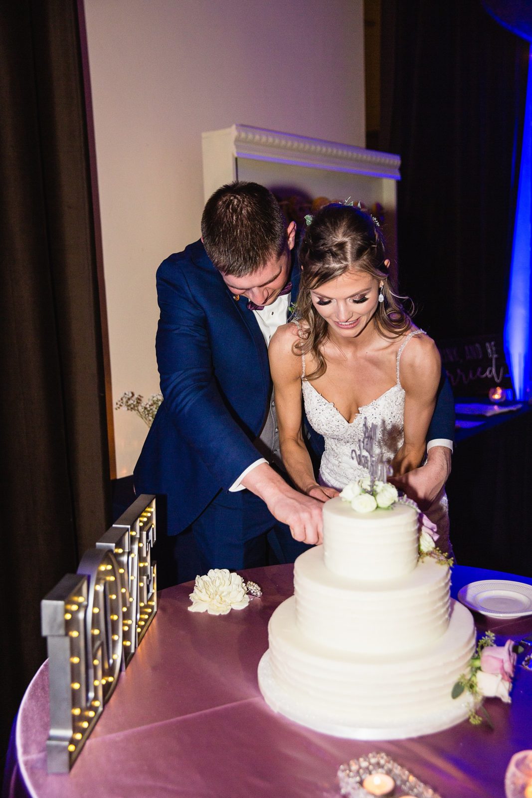 Bride and Groom cutting their wedding cake at their Superstition Manor wedding reception by Arizona wedding photographer PMA Photography.