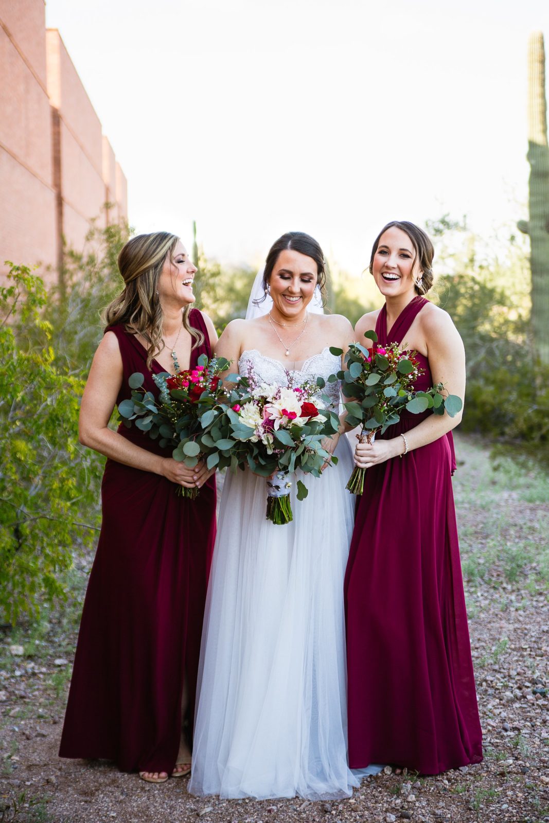Bride and bridesmaids laughing together at Arizona Heritage Center at Papago Park wedding by Tempe wedding photographer PMA Photography.