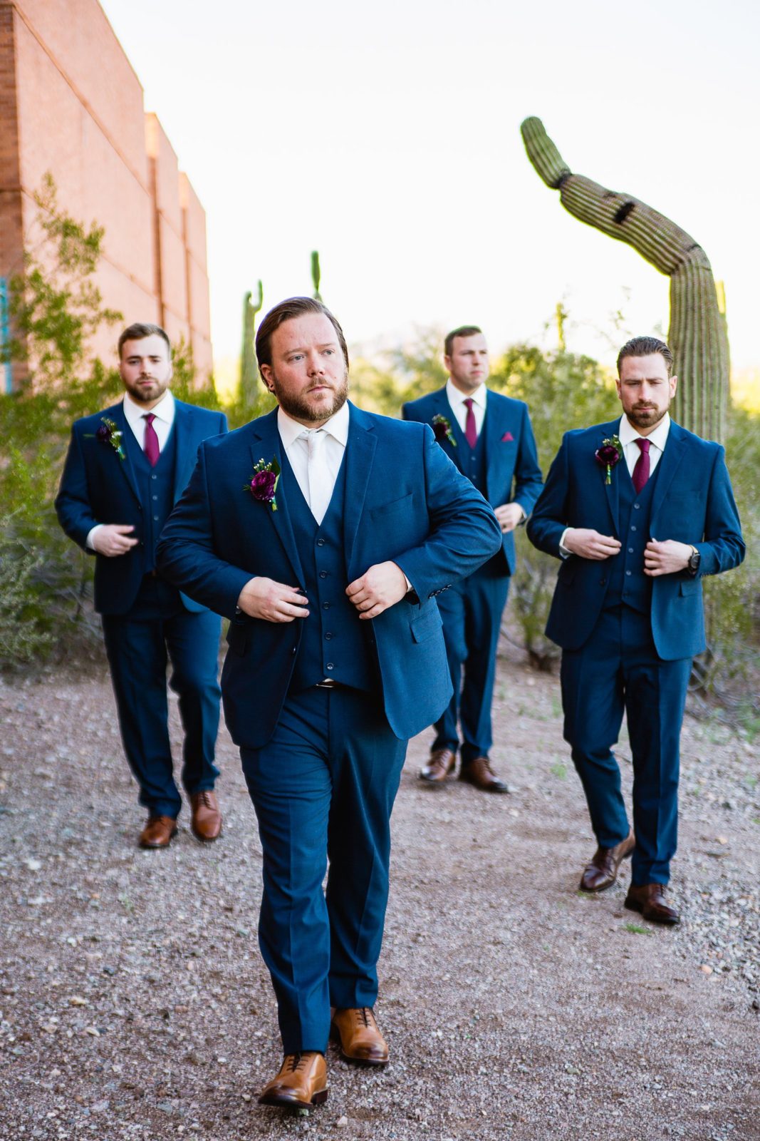 Groom and groomsmen walking together at a Arizona Heritage Center at Papago Park wedding by Arizona wedding photographer PMA Photography.