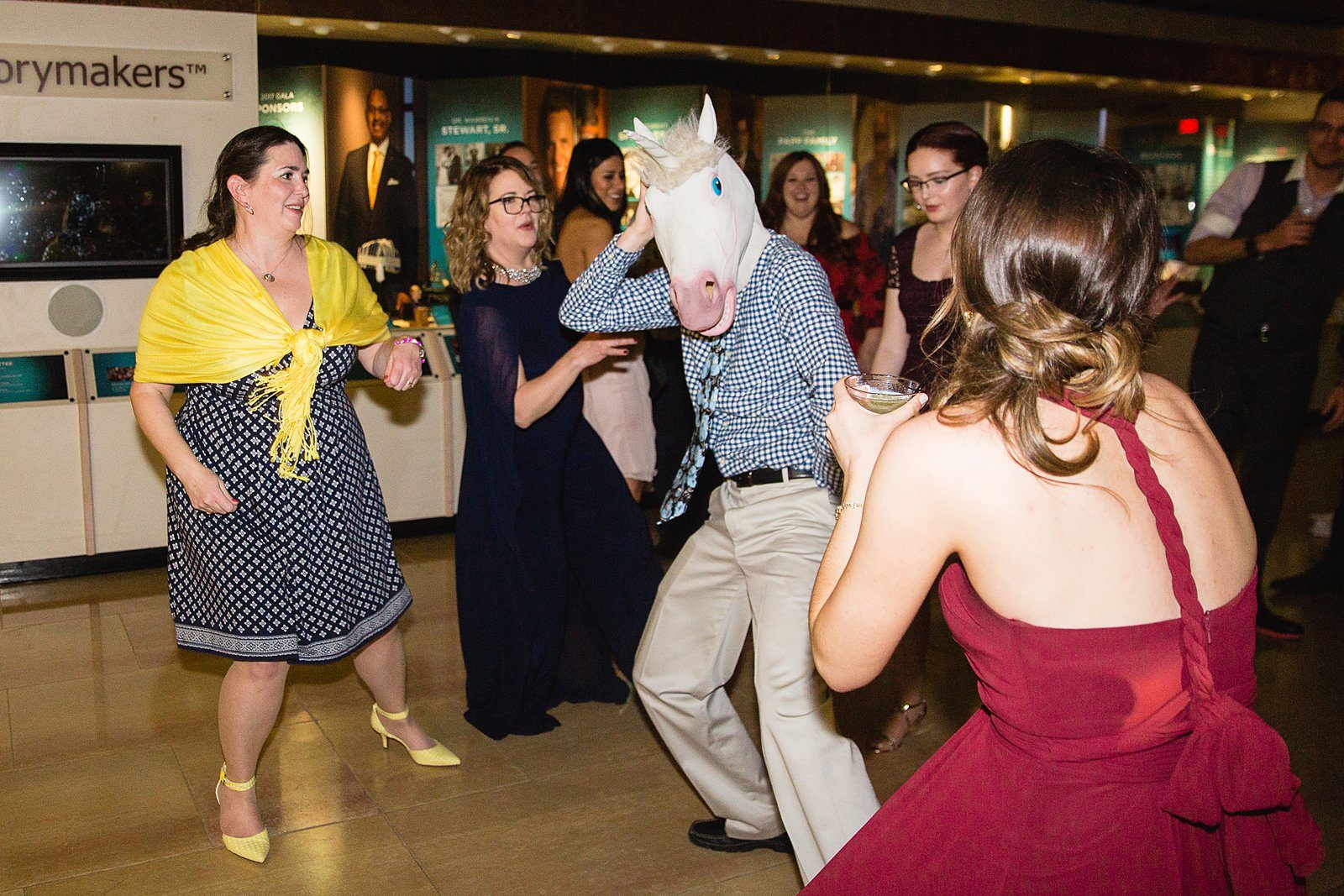 Guest dancing in a unicorn mask at a wedding reception by Arizona wedding photographer PMA Photography.