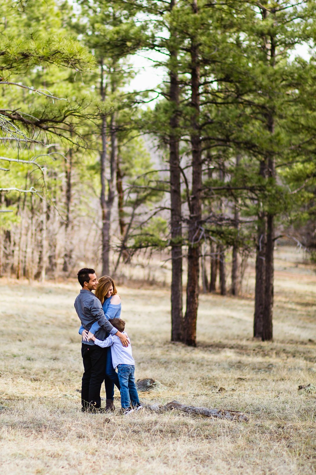 Couple pose with their son during their Flagstaff engagement session by Arizona wedding photographer PMA Photography.