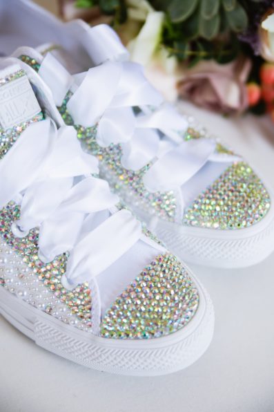 Bride's alternative wedding shoes: rhinestone converse with white ribbon laces by PMA Photography.