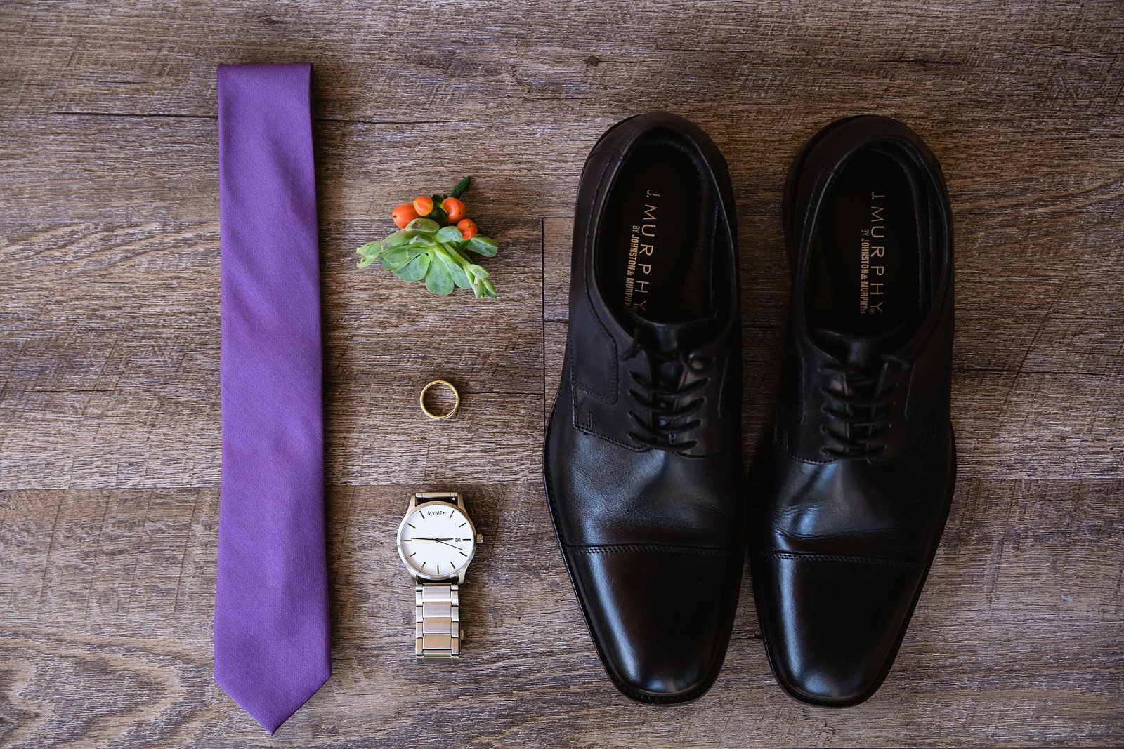 Groom's wedding details of black dress shoes, purple tie, silver watch, and succulent boutonniere by Arizona wedding photographer PMA Photography.