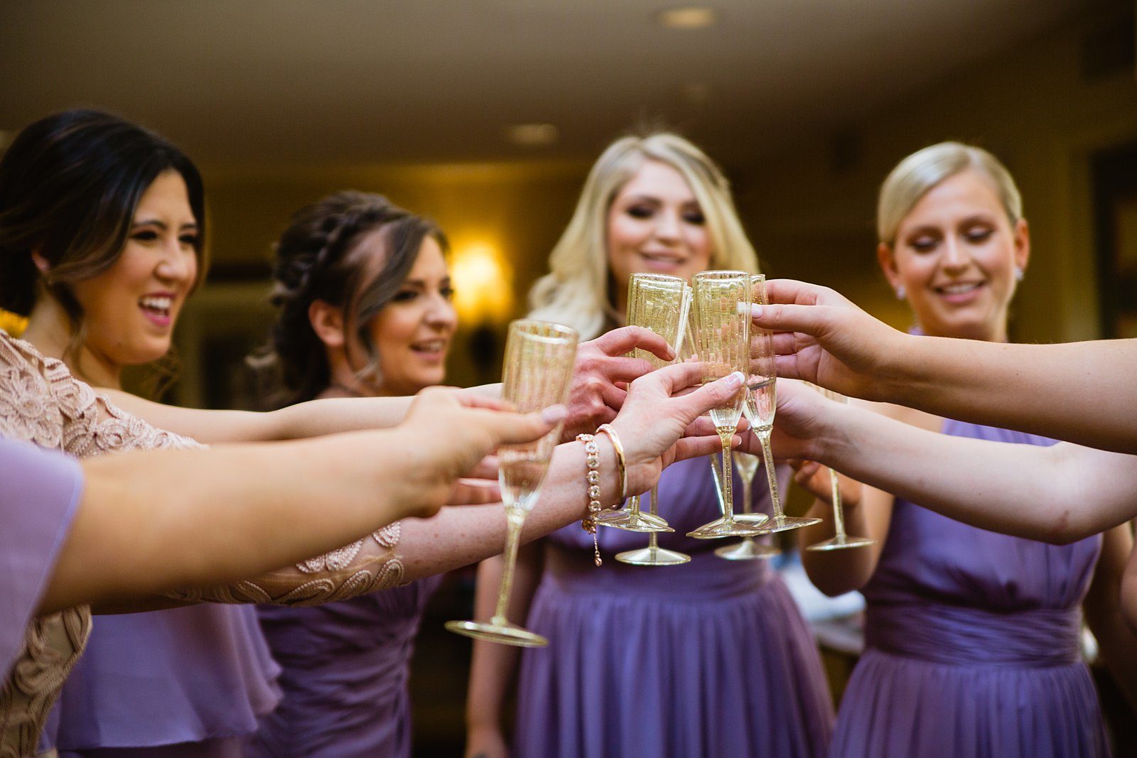 Bride and bridesmaids toasting with champagne before the wedding ceremony by PMA Photography.