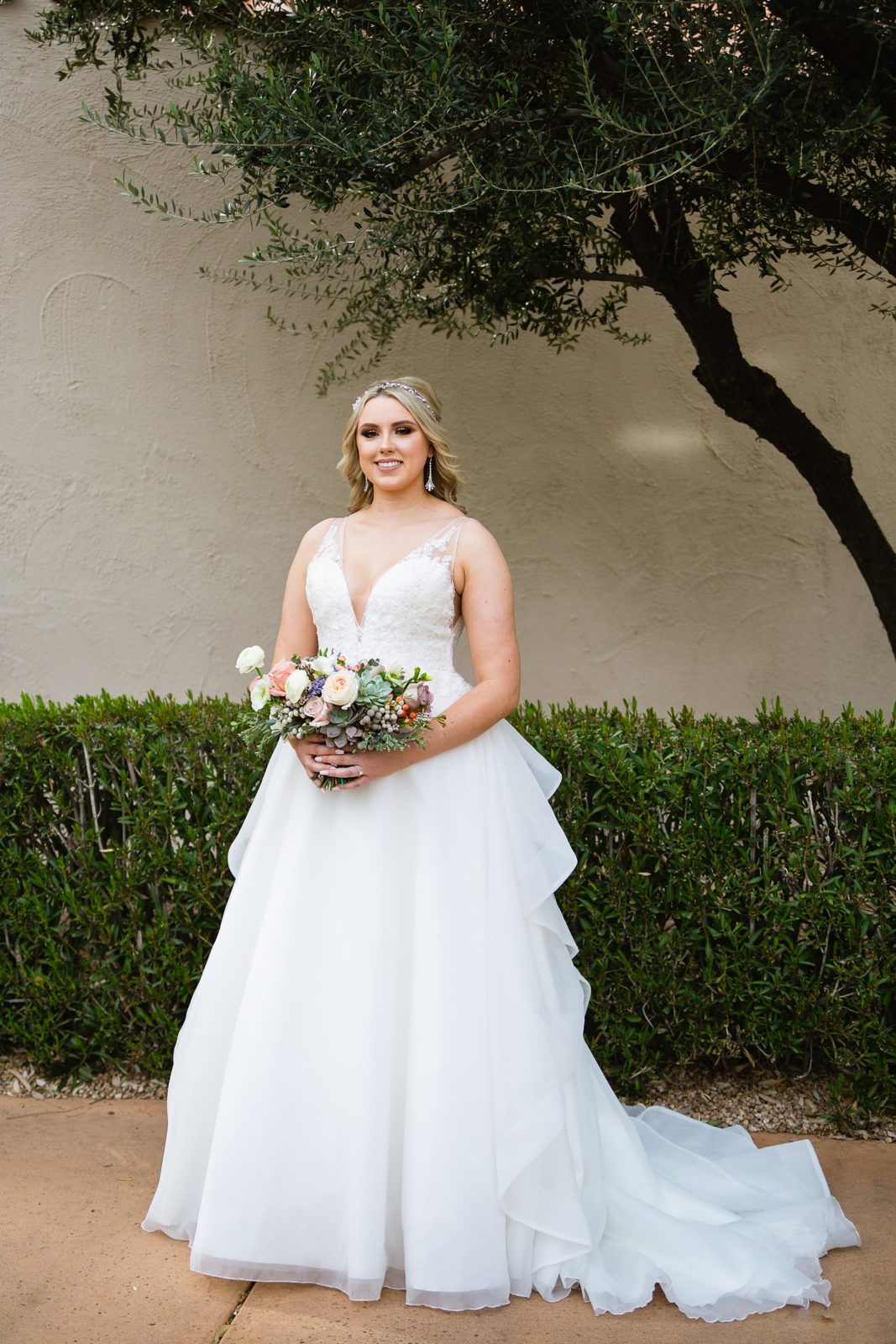 Bride in a romantic wedding dress with lace details by Arizona wedding photographer PMA Photography.