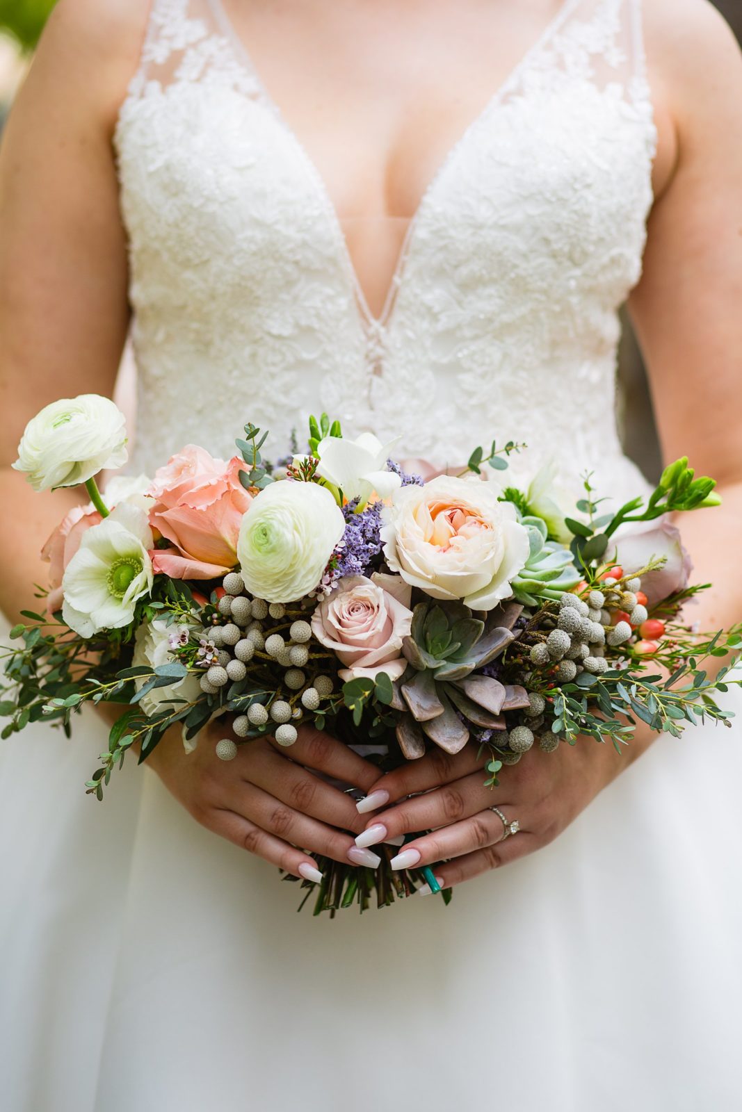 Bride's tight and wild bridal bouquet with pink and white flowers and succulents by PMA Photography.