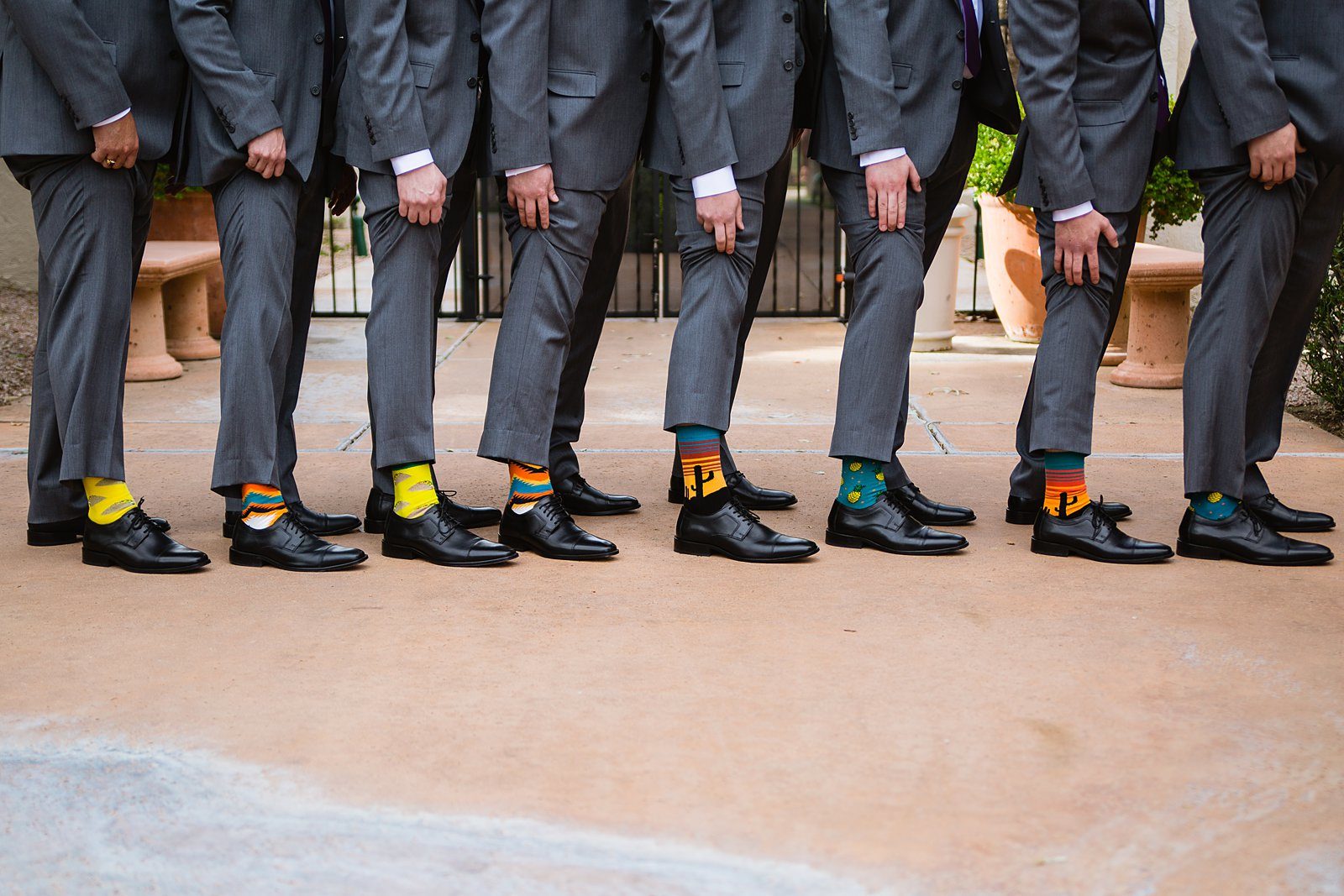 Groomsmen showing off their fun wedding socks under their suits by PMA Photography.