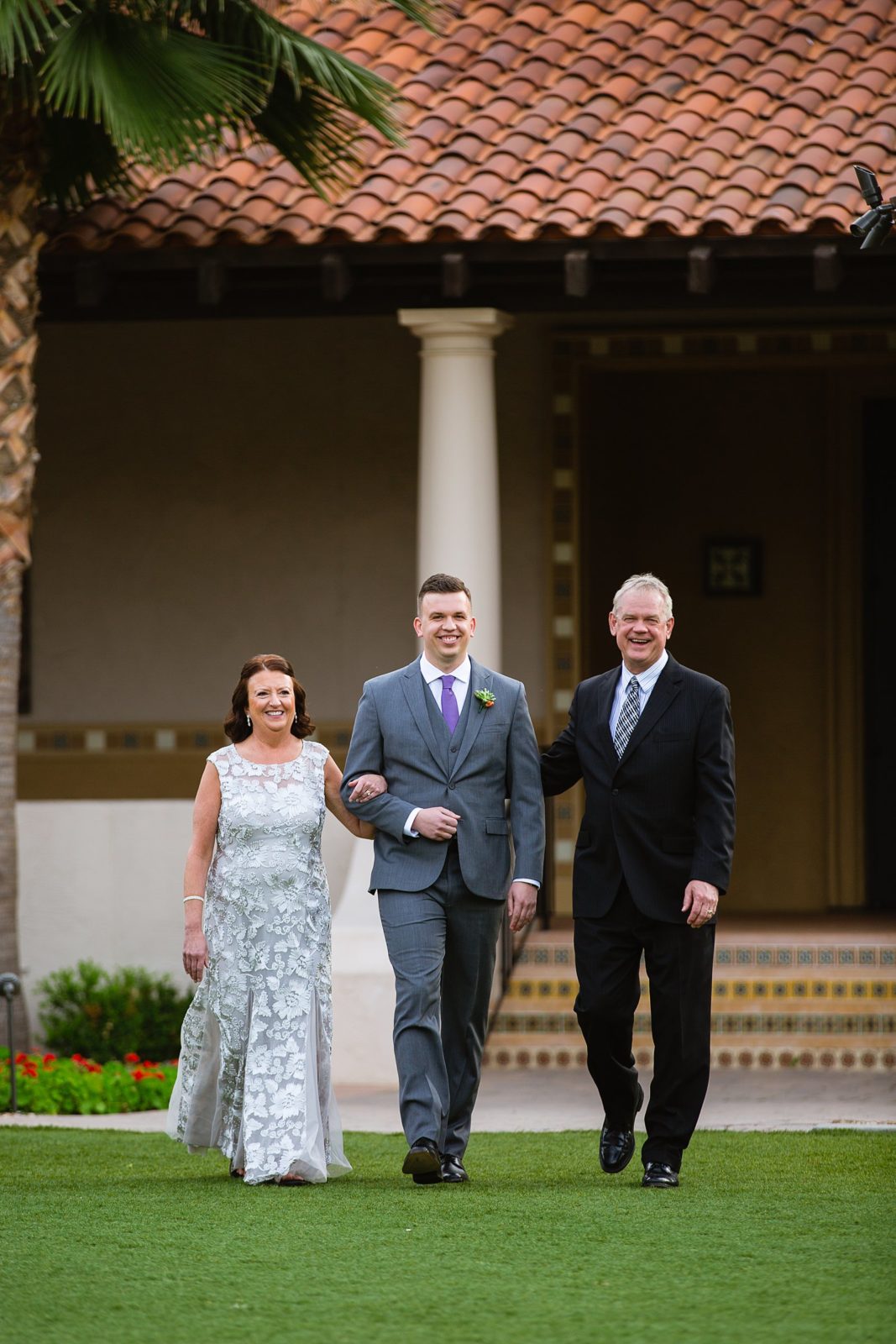 Groom walking down the aisle with his parents during The Scottsdale Resort at McCormick Ranch wedding ceremony by Arizona wedding photographer PMA Photography.