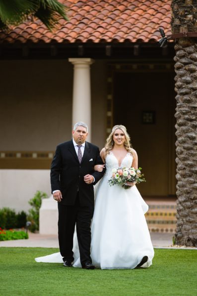 Bride walking down aisle during The Scottsdale Resort at McCormick Ranch wedding ceremony by Arizona wedding photographer PMA Photography.