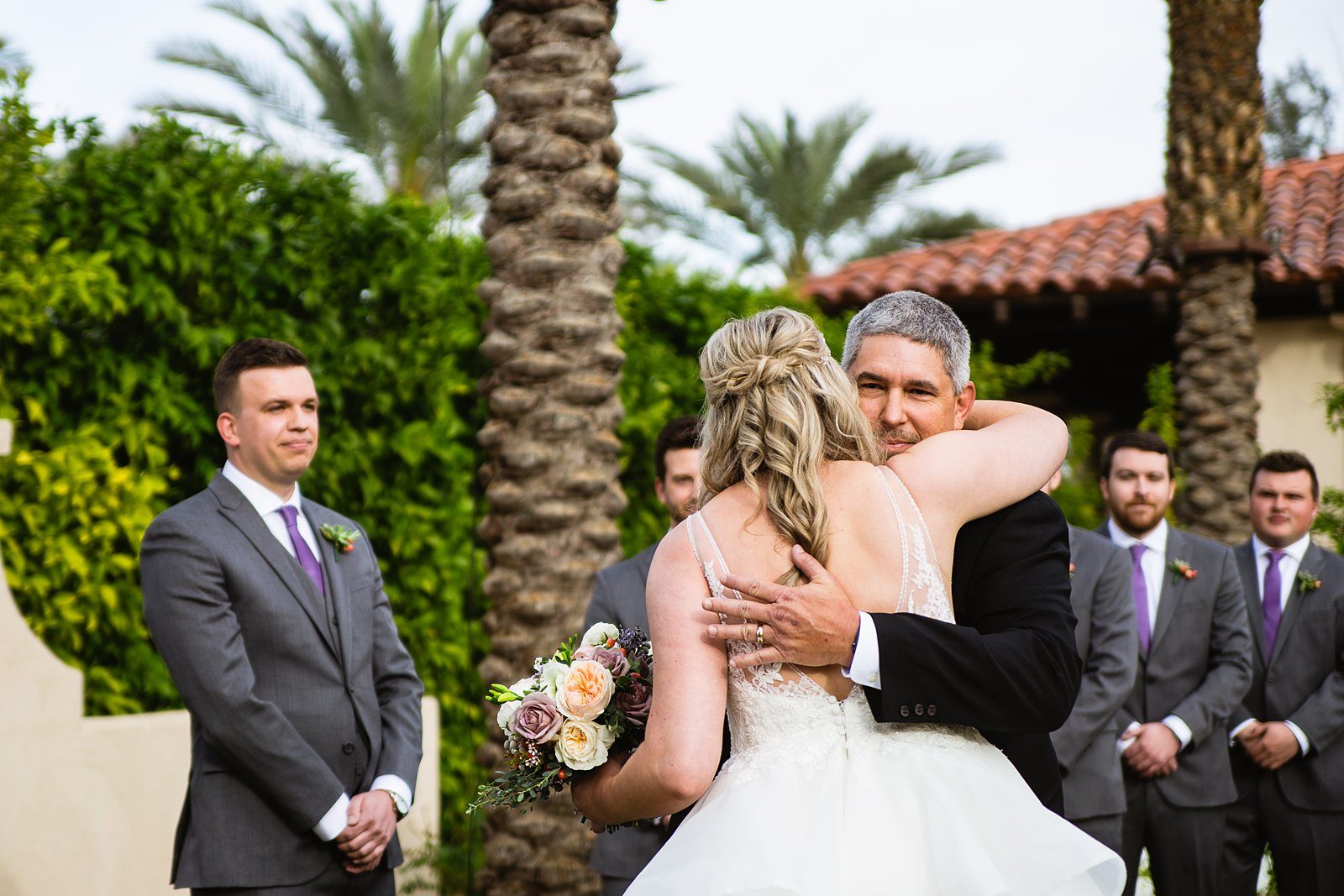 Bride hugging her father during her wedding ceremony at The Scottsdale Resort by PMA Photography.