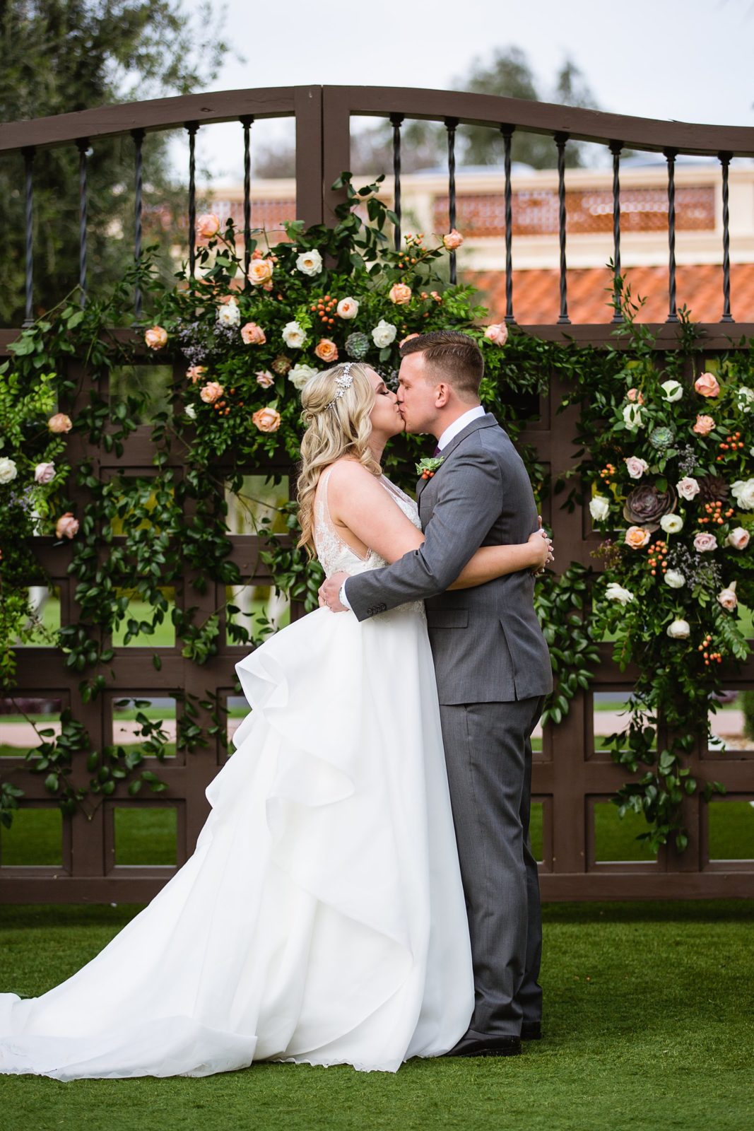 Bride and Groom share their first kiss during their wedding ceremony at The Scottsdale Resort at McCormick Ranch by Arizona wedding photographer PMA Photography.