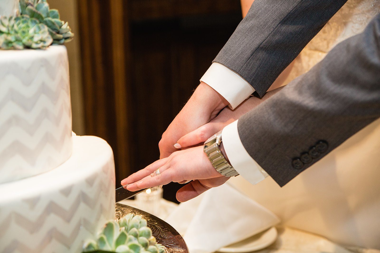 Bride and Groom cutting their wedding cake at their The Scottsdale Resort at McCormick Ranch wedding reception by Arizona wedding photographer PMA Photography.