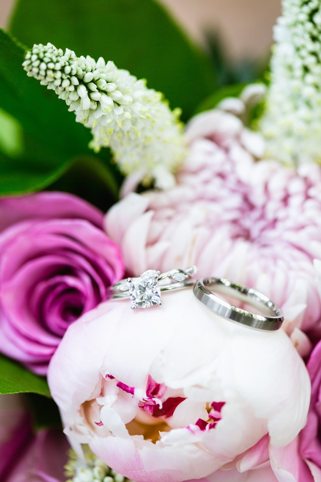 White gold garden inspired wedding rings in a pink garden inspired bouquet by Mesa wedding photographer PMA Photography.