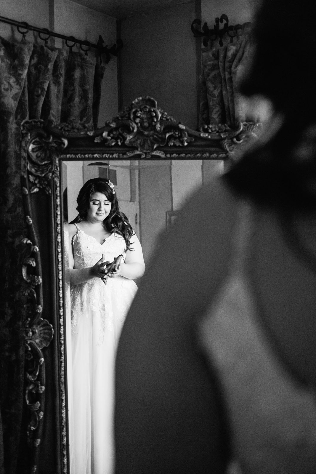 Bride in the reflection of a vintage inspired mirror while getting ready for her wedding by Arizona wedding photographer PMA Photography.