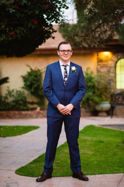Groom in a navy suit with a floral tie for his Wright House Provencal wedding by PMA Photography.