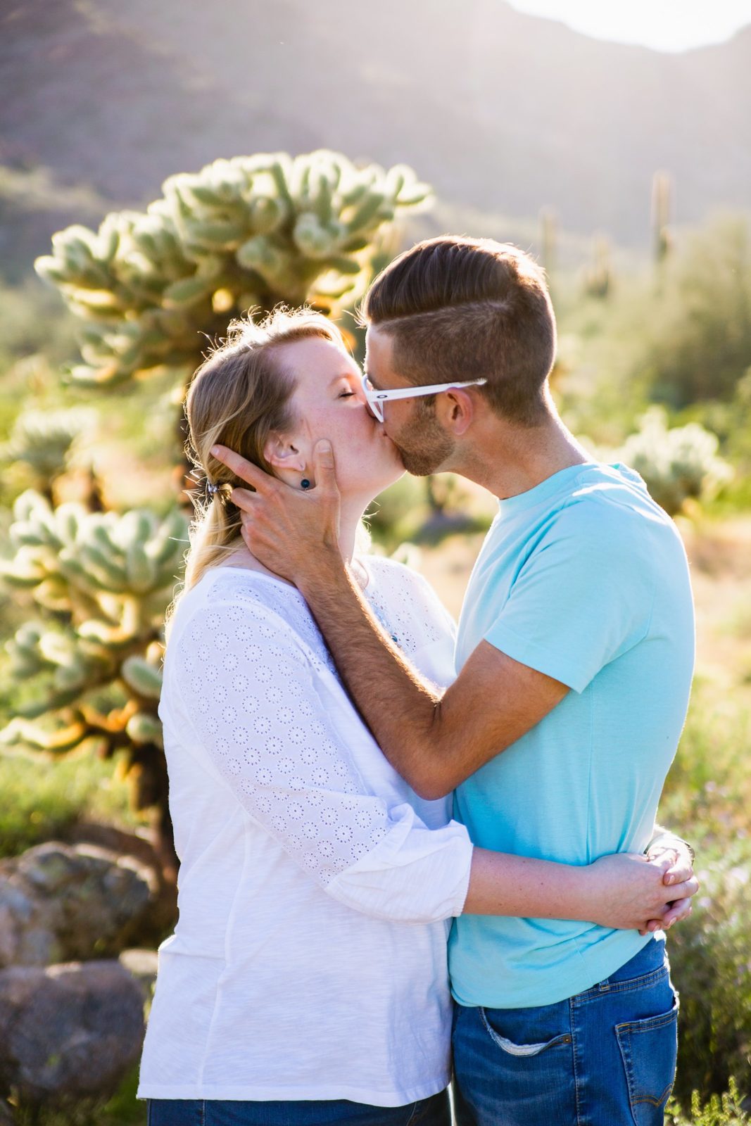 Couple share a kiss during their White Tanks engagement session by Wadell wedding photographer PMA Photography.