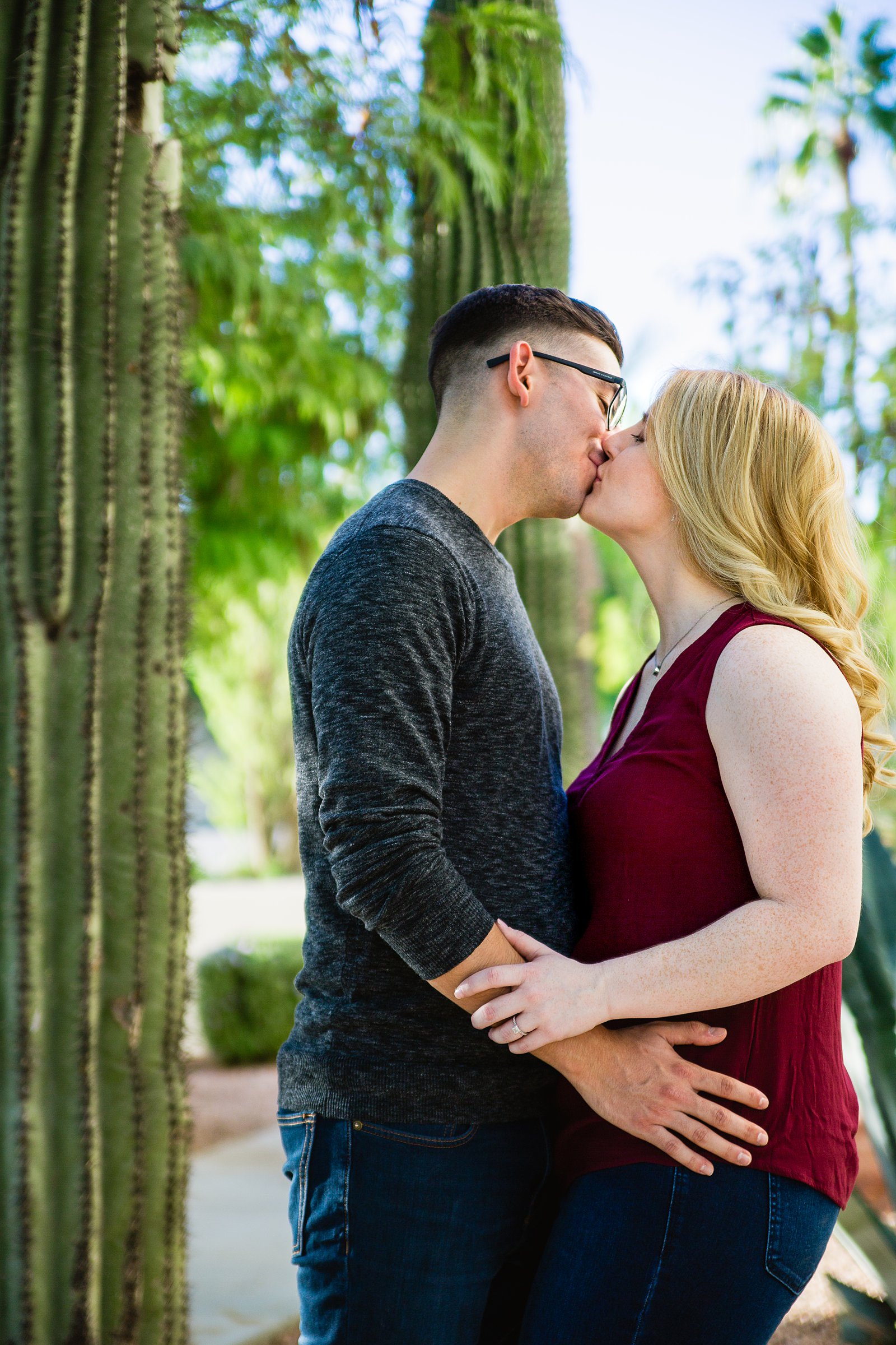 Couple share a kiss during their Scottsdale engagement session by Arizona wedding photographer PMA Photography.