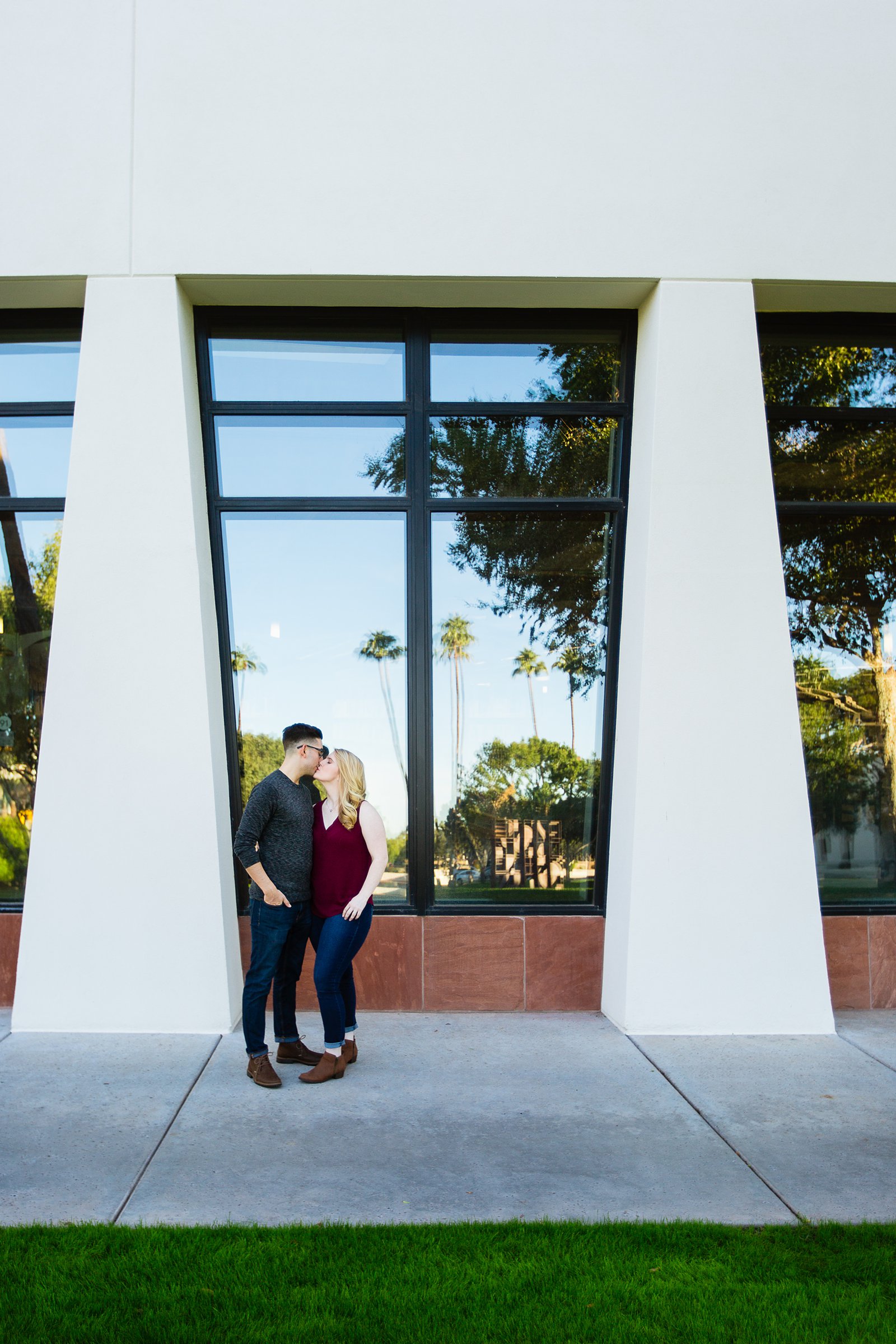 Couple share a kiss during their Scottsdale Civic Center engagement session by Scottsdale wedding photographer PMA Photography.
